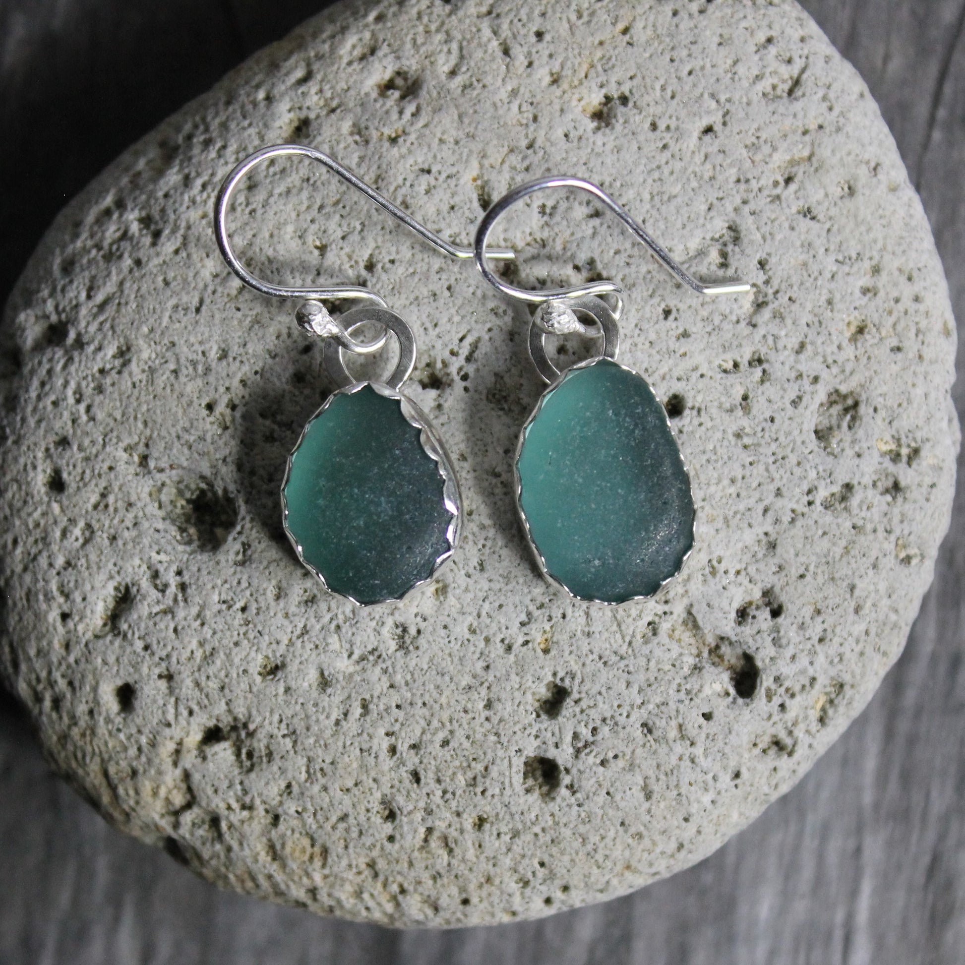 Dark teal sea glass set in a fine and sterling silver scalloped bezel setting and attached to handmade ear wires.  
