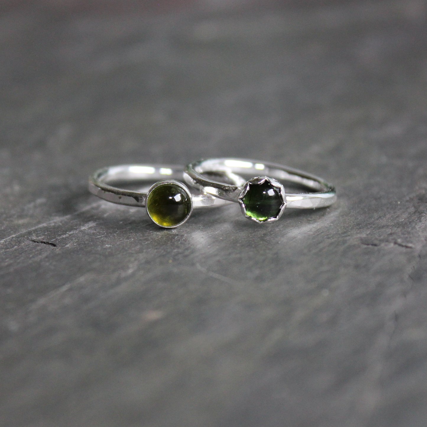 Two Round 6mm green tourmaline gemstone set in a sterling silver bezel setting on a sturdy hammered band. 