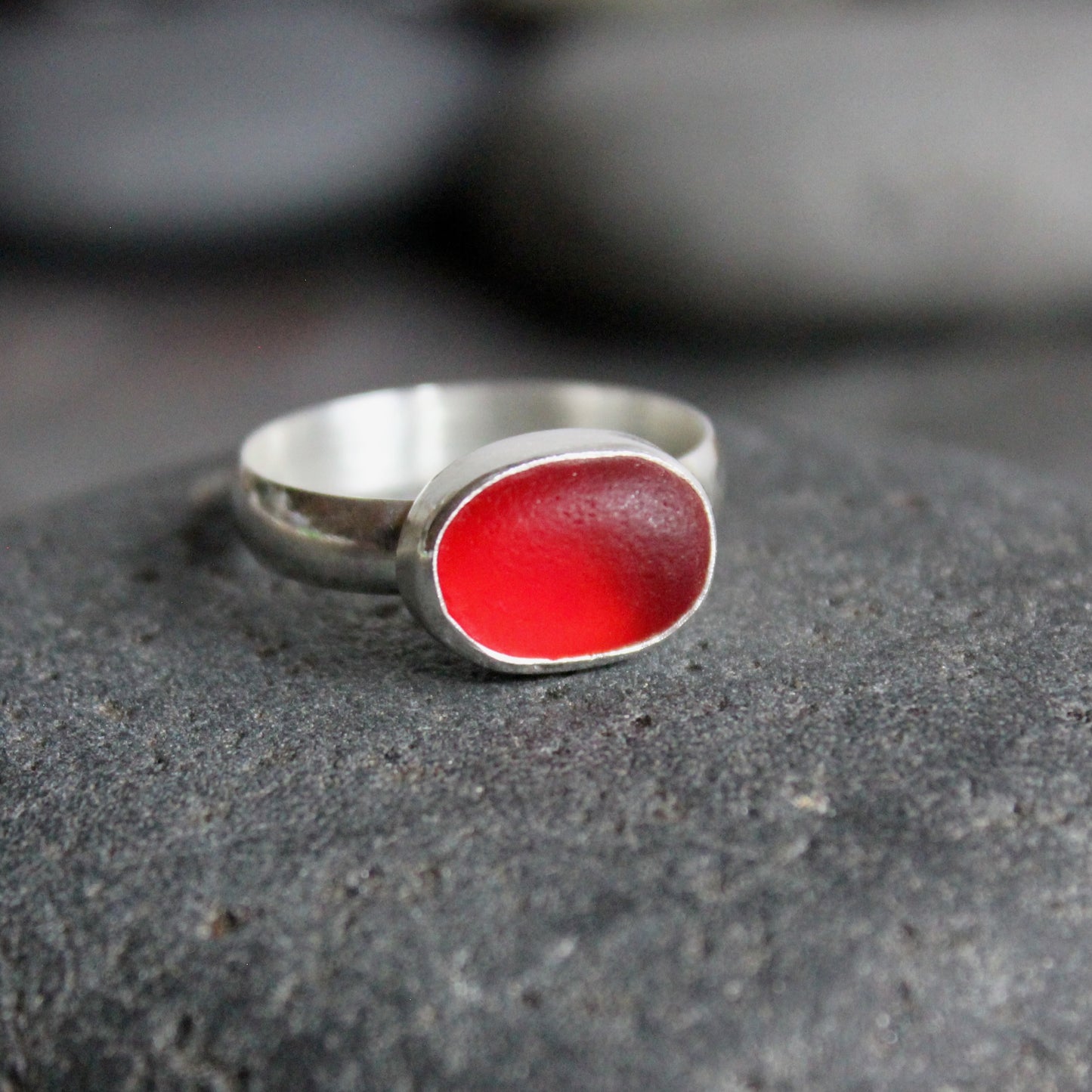 This ring has a piece of rare red sea glass set in a fine & sterling silver bezel setting on a hammered band.  Size 10