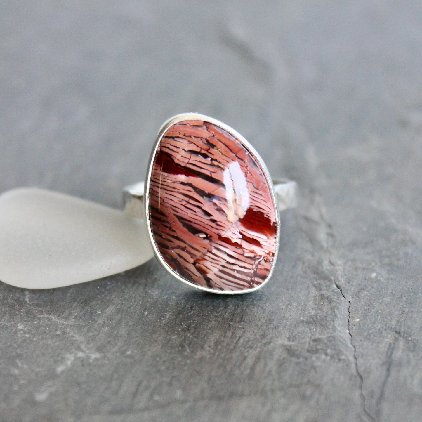 This large ring has a freeform rattlesnake jasper or Howardite cabochon that is set in a fine and sterling silver bezel setting on a sturdy hammered band. Size 11 3/4 Handmade by Will Macy in Corvallis, Oregon.