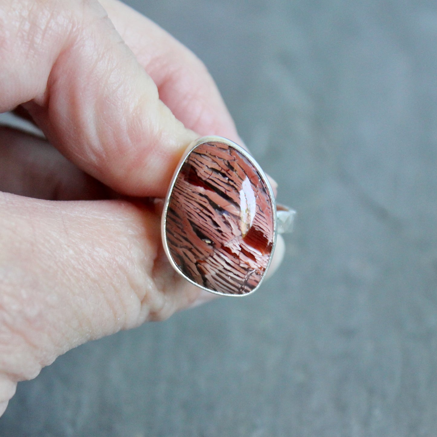 This large ring has a freeform rattlesnake jasper or Howardite cabochon that is set in a fine and sterling silver bezel setting on a sturdy hammered band. Size 11 3/4 Handmade by Will Macy in Corvallis, Oregon.