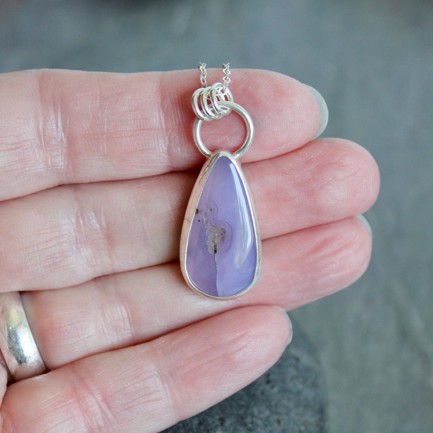 This pendant has a rare holley blue agate cabochon that is set in a fine and sterling silver bezel setting on a sturdy silver chain. Handmade by Will Macy in Corvallis, Oregon.