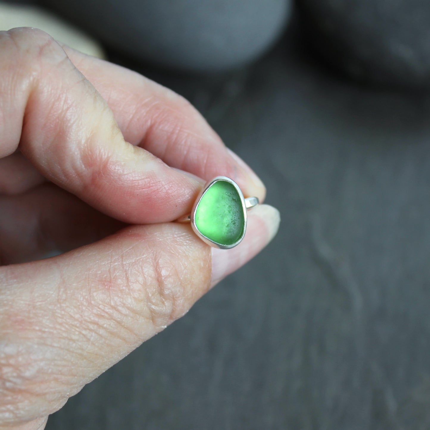 This ring has a small piece of bright green sea glass that is set in a fine and sterling silver bezel setting on a sturdy silver band. Size 5. Handmade by Barb Macy in Corvallis, OR.