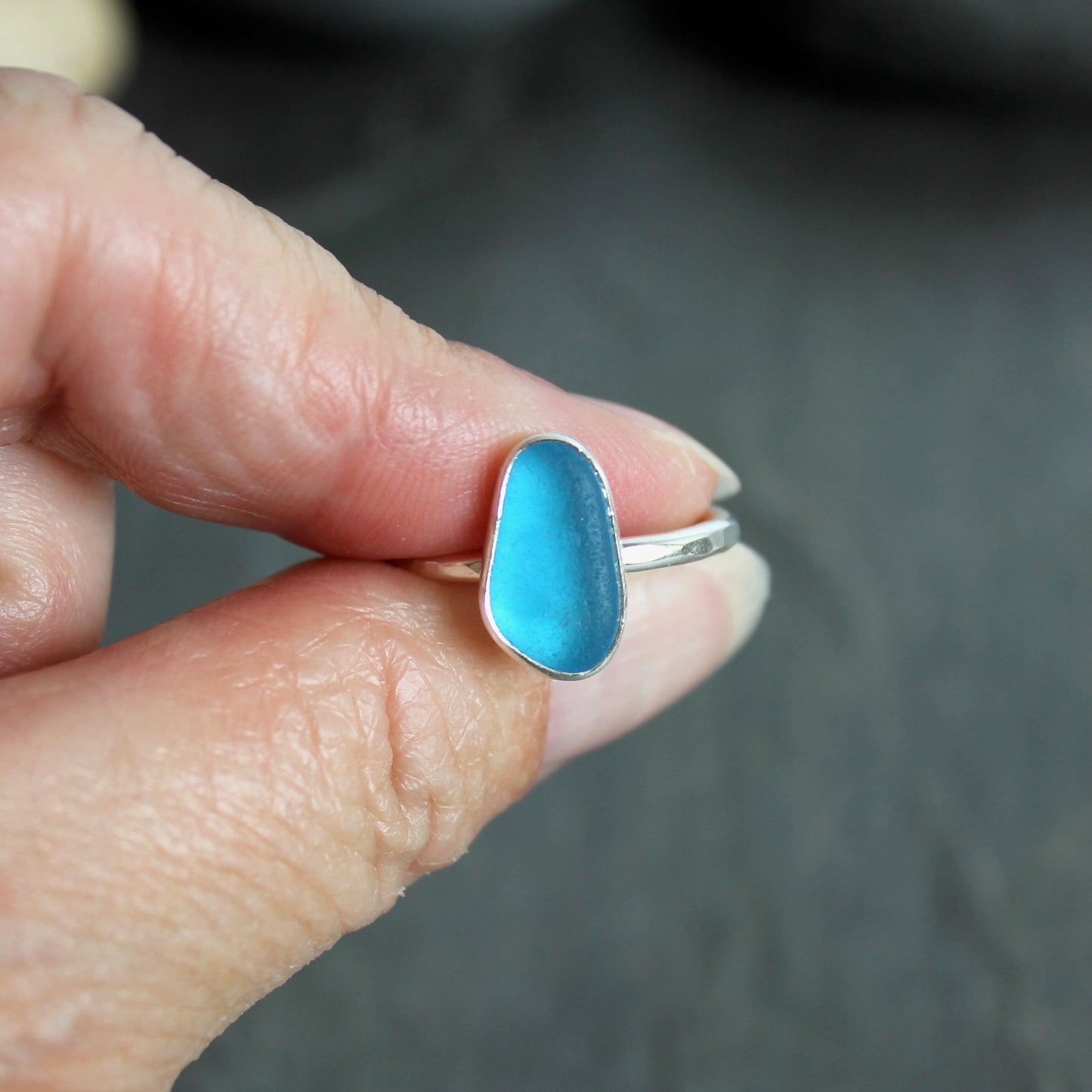 This ring has a piece of electric turquoise blue sea glass that is set in a fine and sterling silver bezel setting on a sturdy silver band. Size 7 3/4 Handmade by Barb Macy in Corvallis, OR.