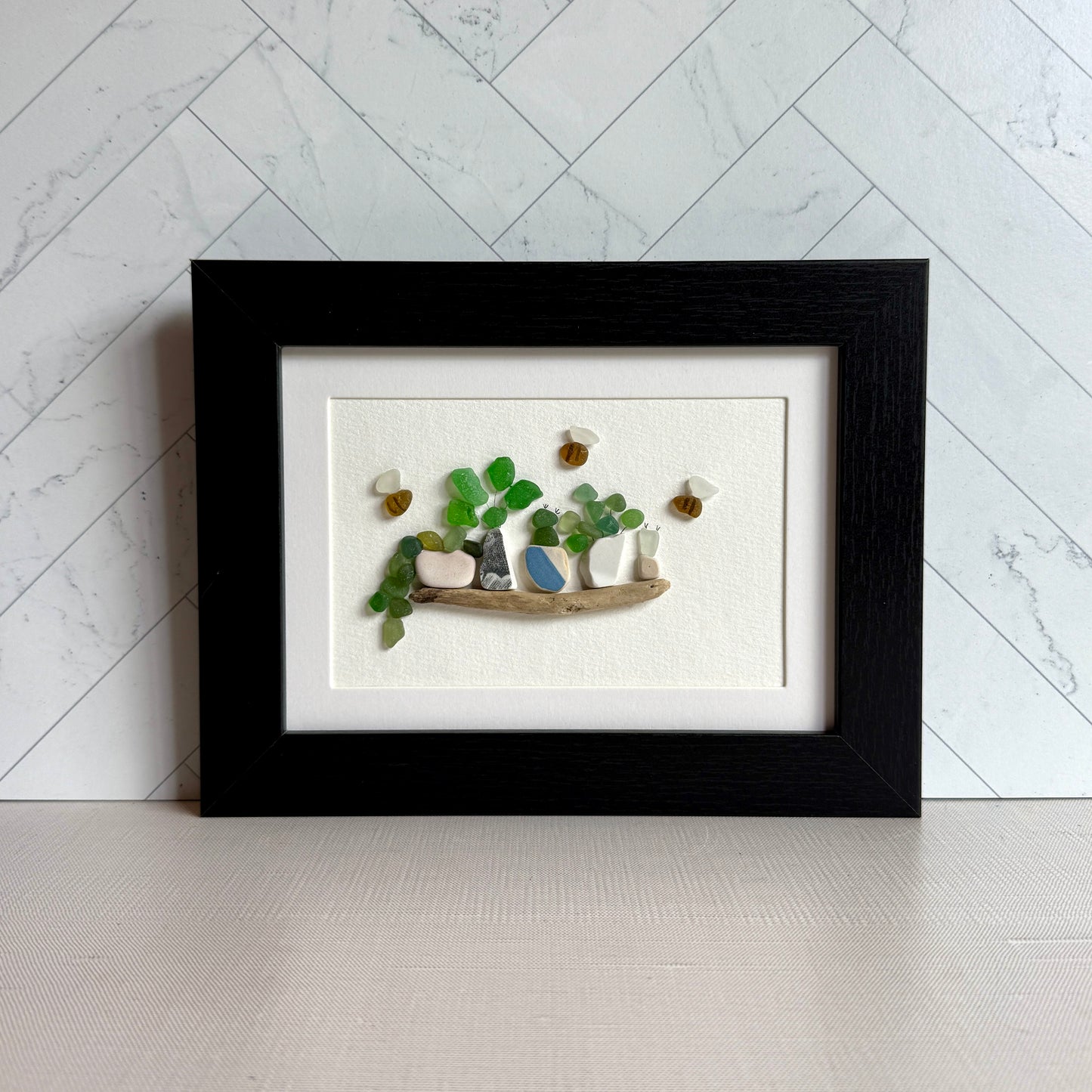 Framed artwork of a garden scene with plants and a bird on a white background