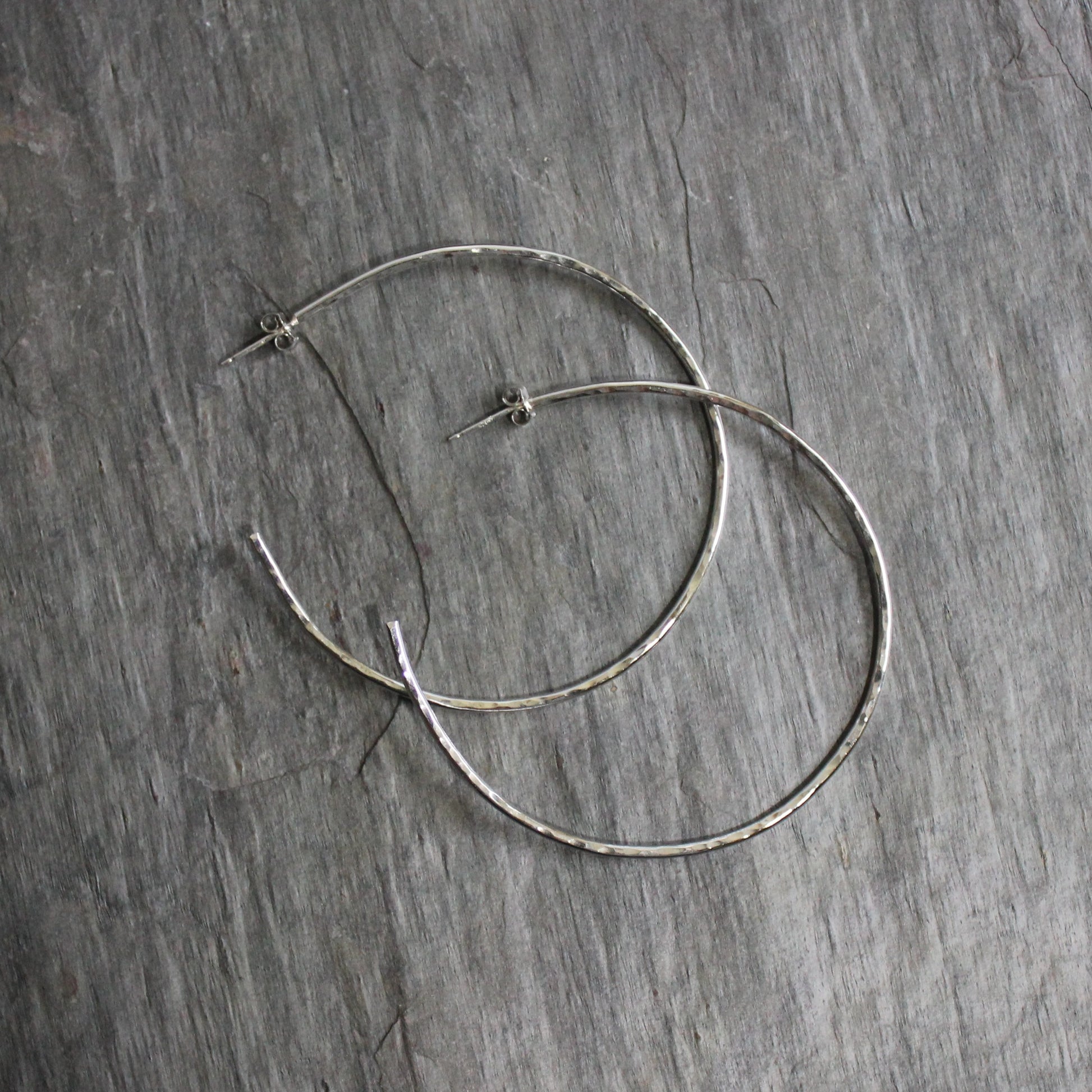 Large Handmade Sterling Silver Hammered Hoop Earrings that measure 2 inches in diameter and finished with sterling silver posts and earring nuts. 