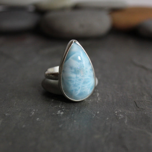This is a large chunky teardrop larimar cabochon set in a fine and sterling silver bezel setting on a sturdy silver band.  Size 12 1/2