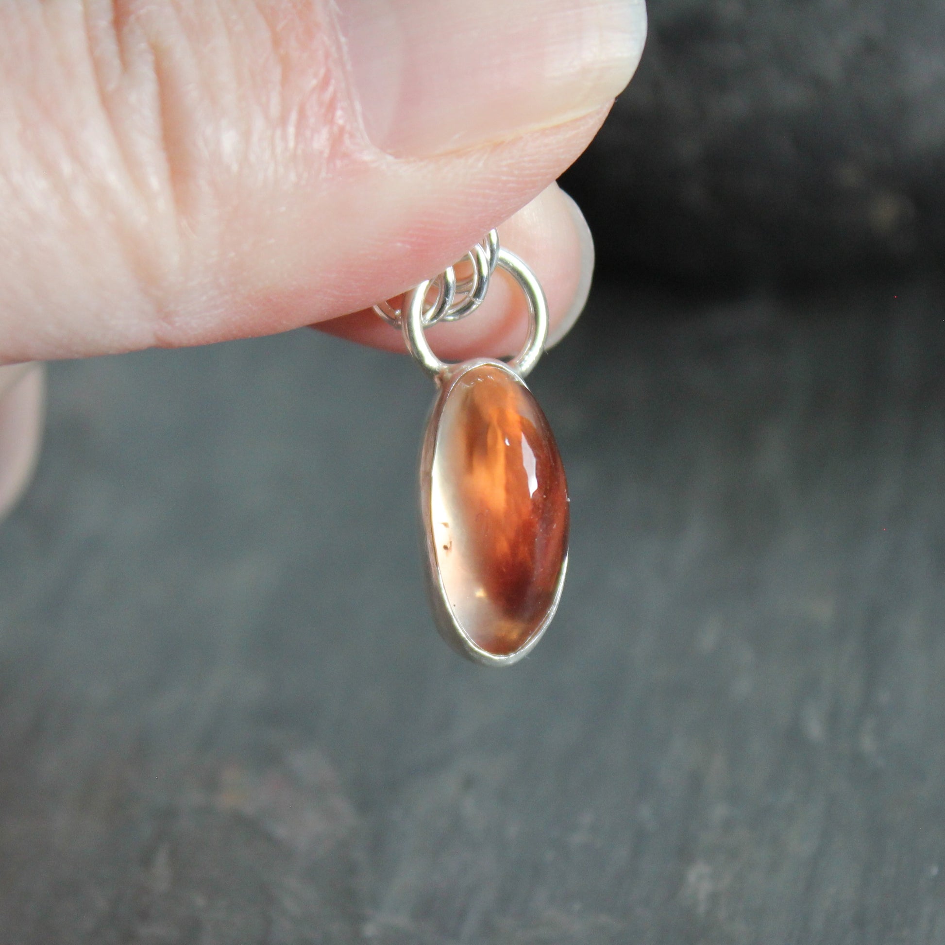 A handmade chunky oblong peach Oregon Sunstone in a sterling and fine silver bezel setting on a sterling silver chain. 