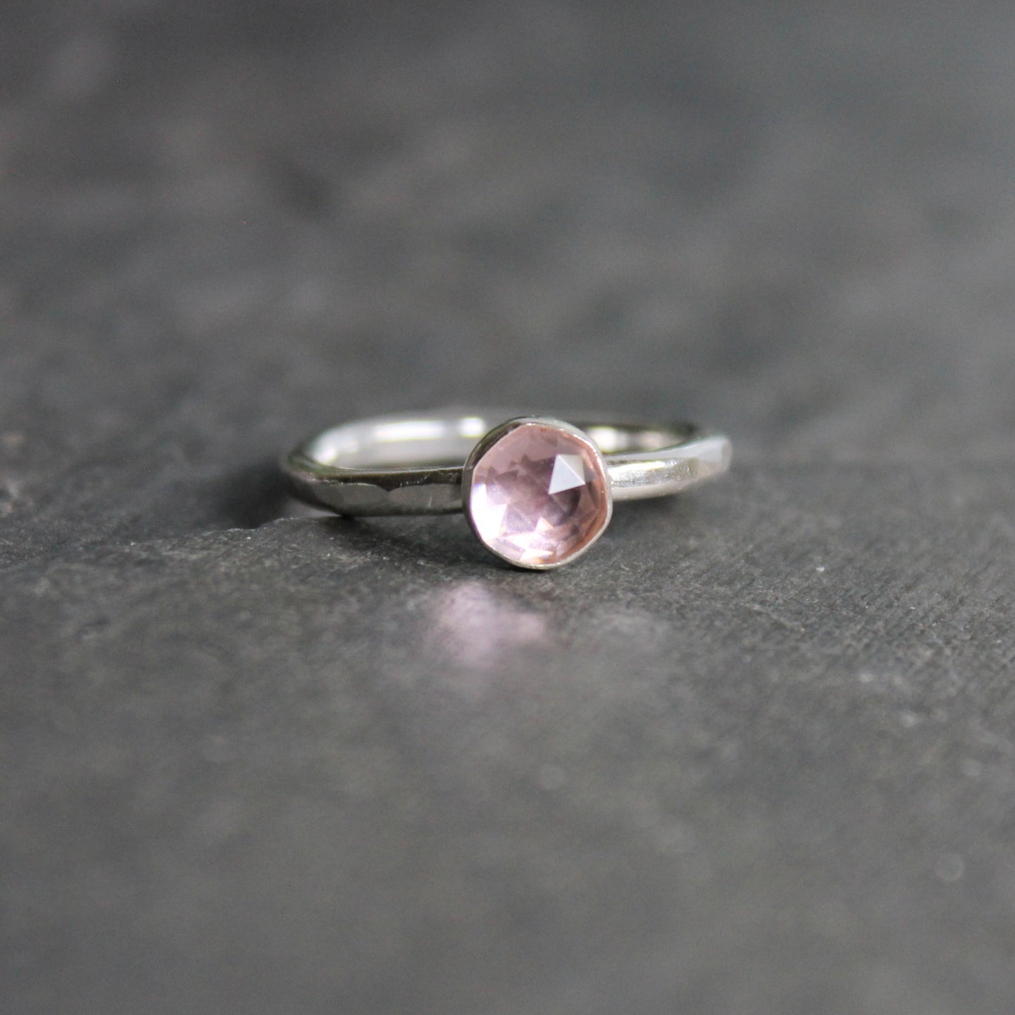 A 6mm round rose cut bezel set morganite gemstone on a sturdy handmade sterling silver band.