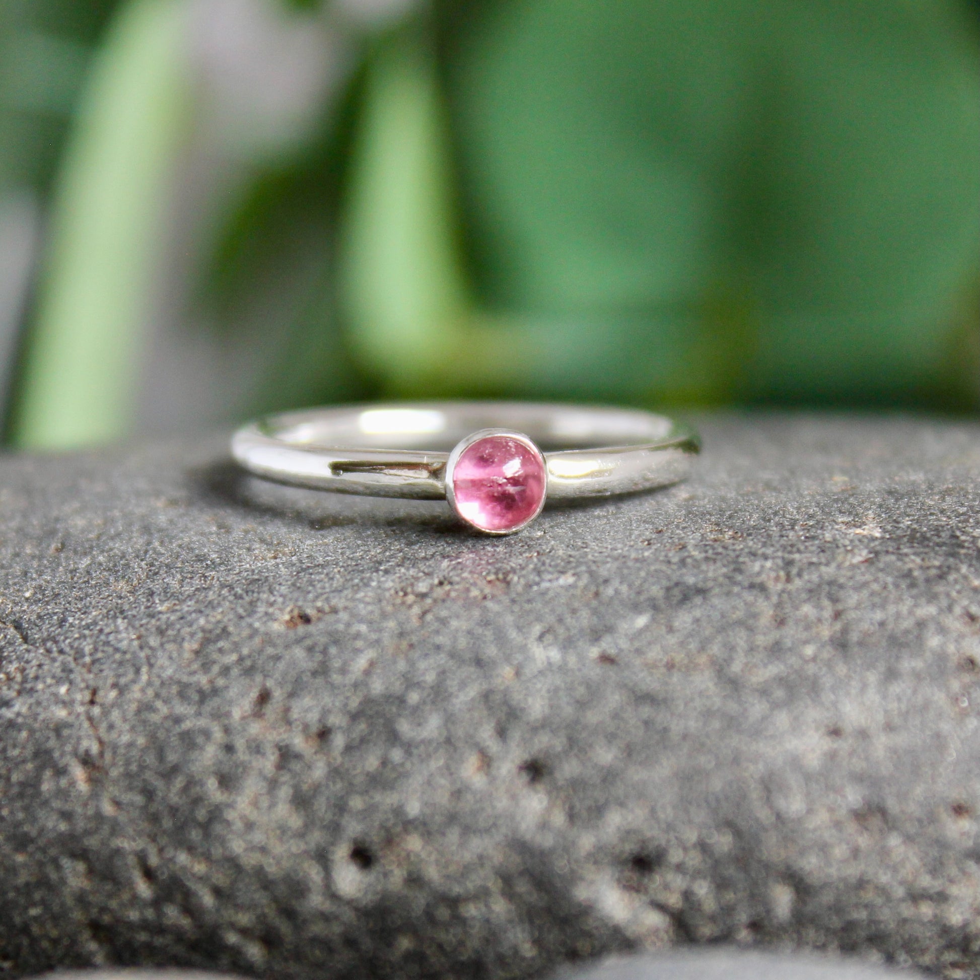 a 4mm round pink tourmaline set in a sterling silver bezel on a sturdy silver band. 