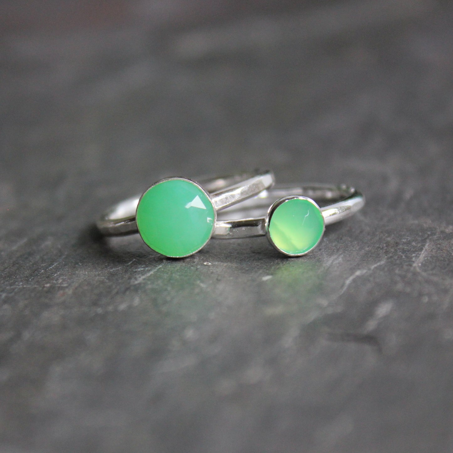 A 6mm or 8mm rose cut round chrysoprase cabochon set in a sterling silver bezel setting on a sturdy silver band. 