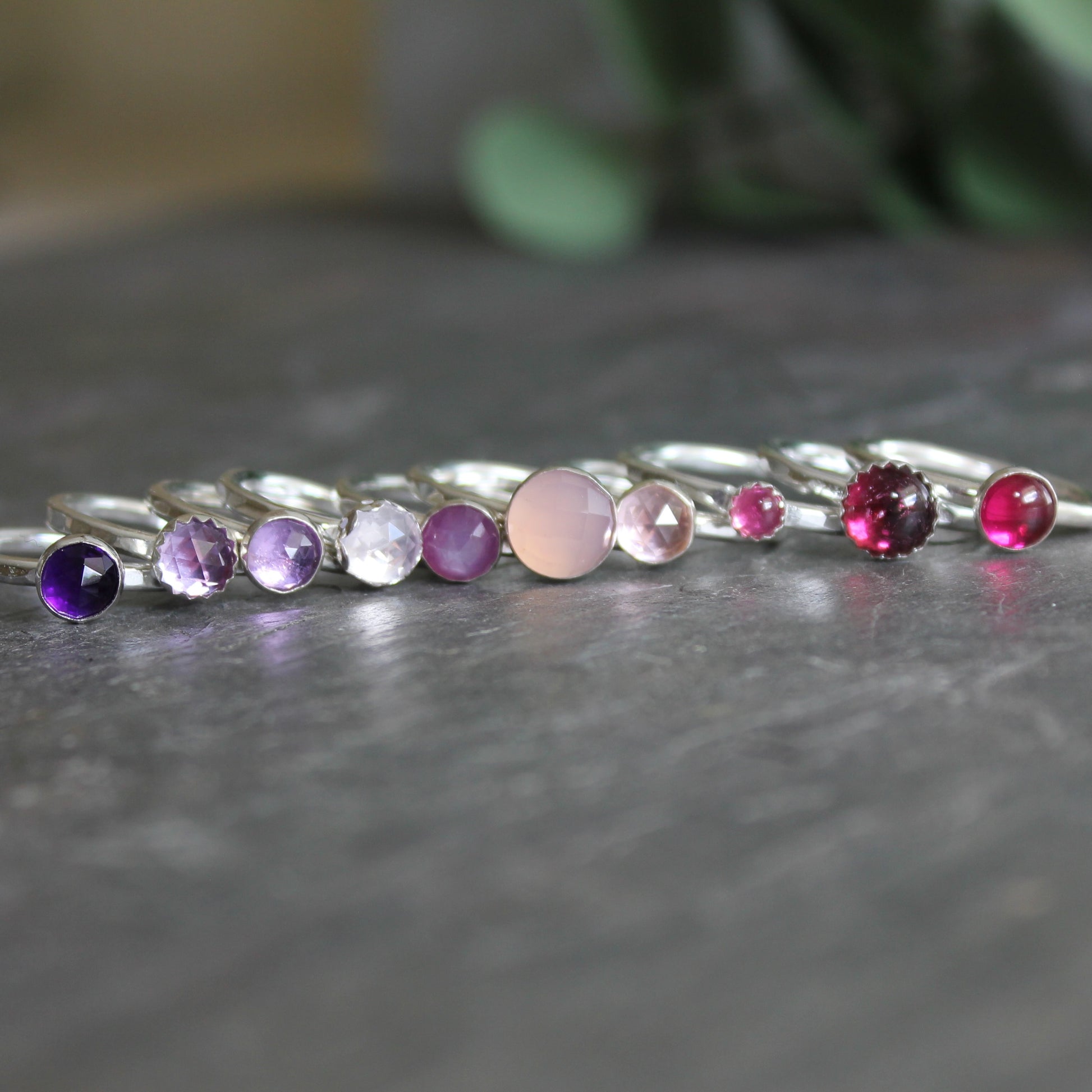 a selection of pinks and purples gemstone stacking rings handmade by Barb Macy in Corvallis, OR. 