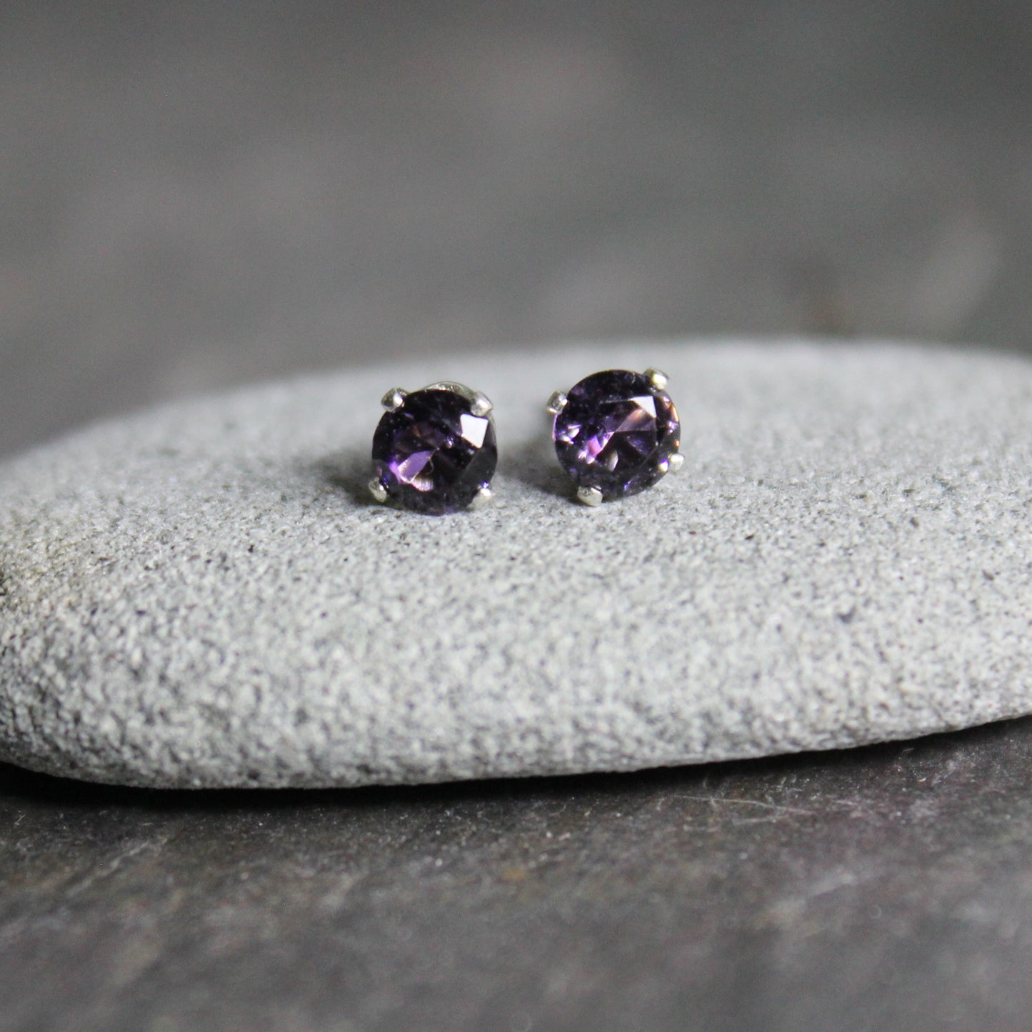 These stud earrings have 4mm round faceted lab created amethysts set in 4-prong sterling silver stud earring settings with ear nuts.