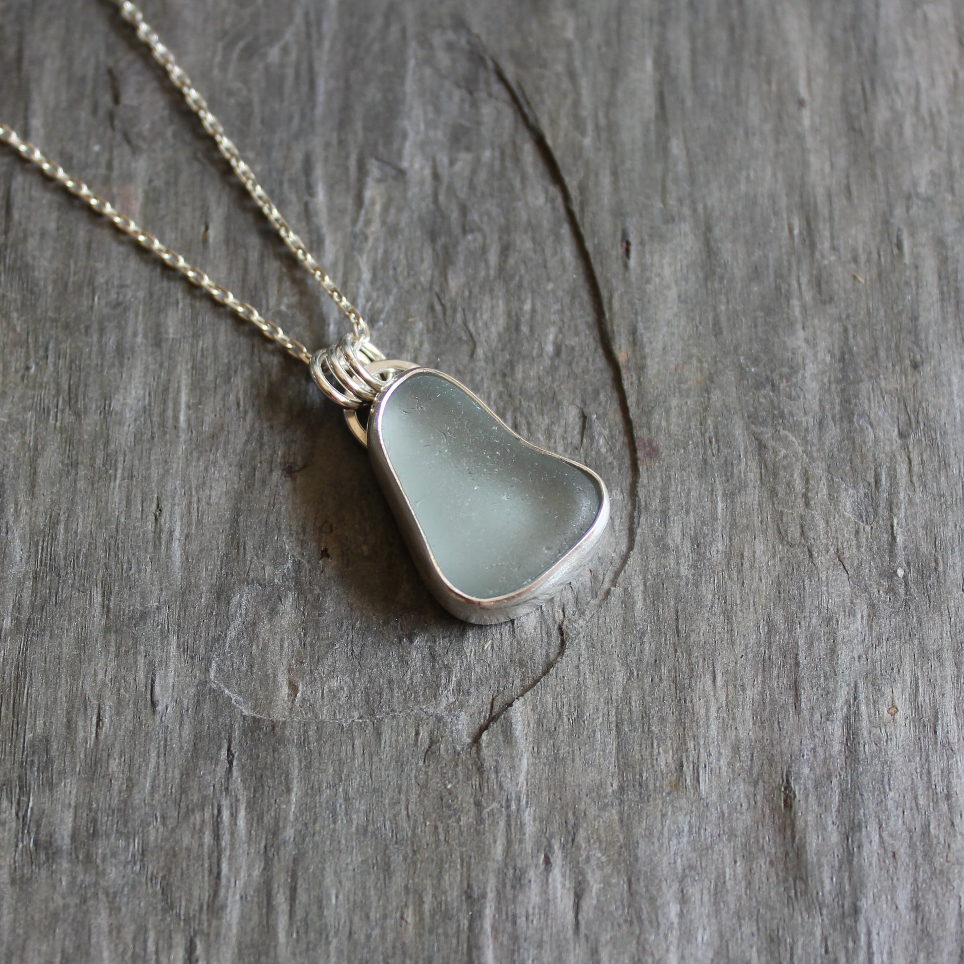 This pendant has a chunky piece of gray sea glass and it is set in a fine and sterling silver bezel setting with an 18" chain.  