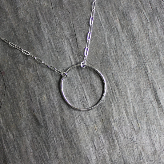 Sterling silver hammered circle that is about 1 inch in diameter attached to sterling silver chain for a finished necklace