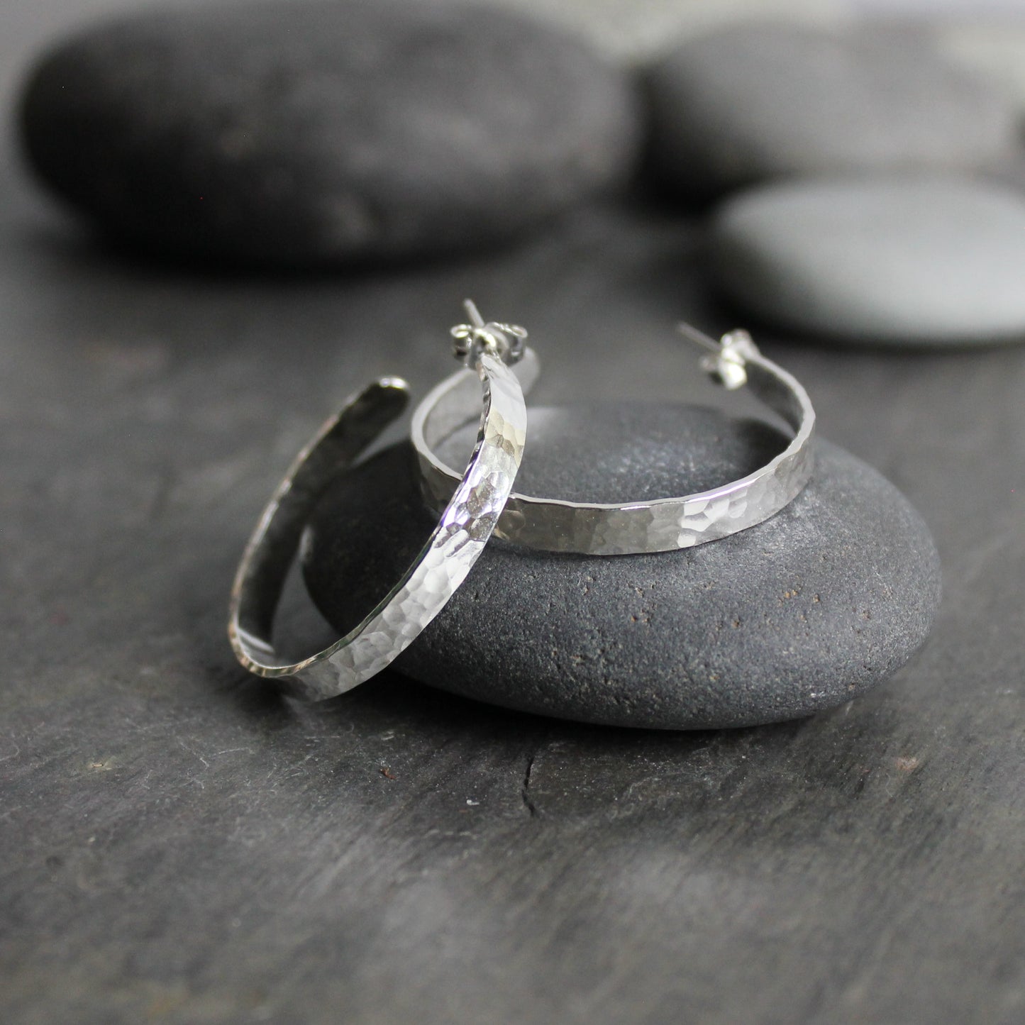 Handmade sterling silver 4mm wide hammered 1 1/4 inch diameter hoops with sterling silver posts.