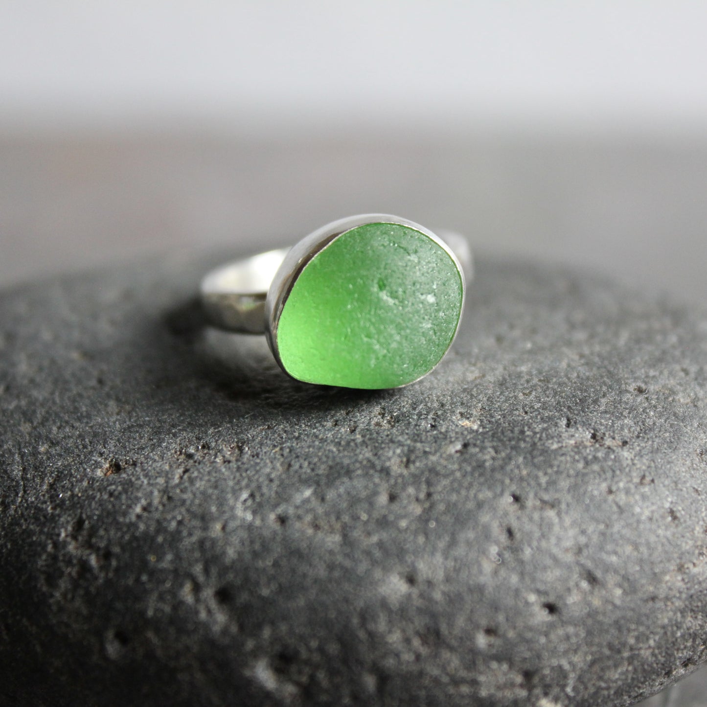 This ring has a chunky roundish piece of bright green sea glass that is set in a fine and sterling silver bezel setting on a sturdy hammered band.  Size 7 1/4