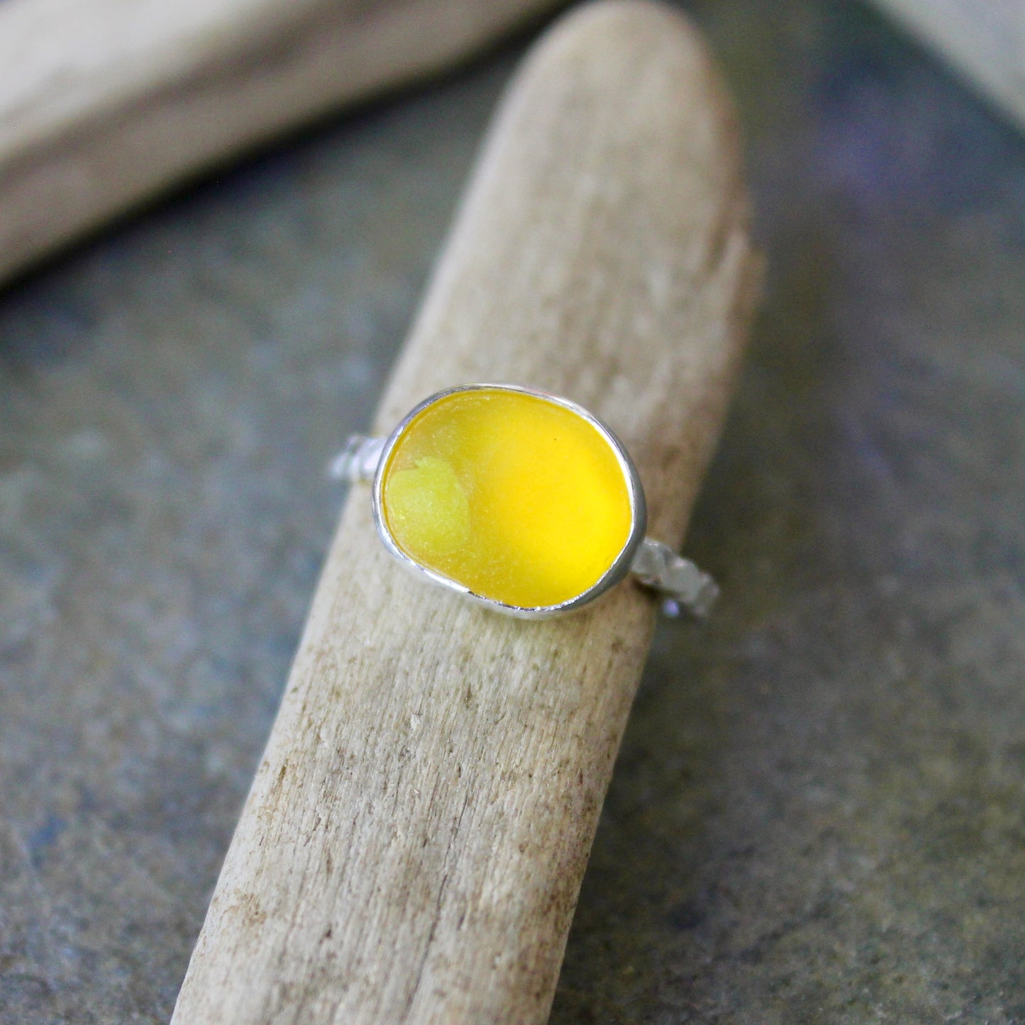 This is a rare piece of golden yellow sea glass set in a fine and sterling silver bezel setting on a twisted wire band.  Size 5 3/4