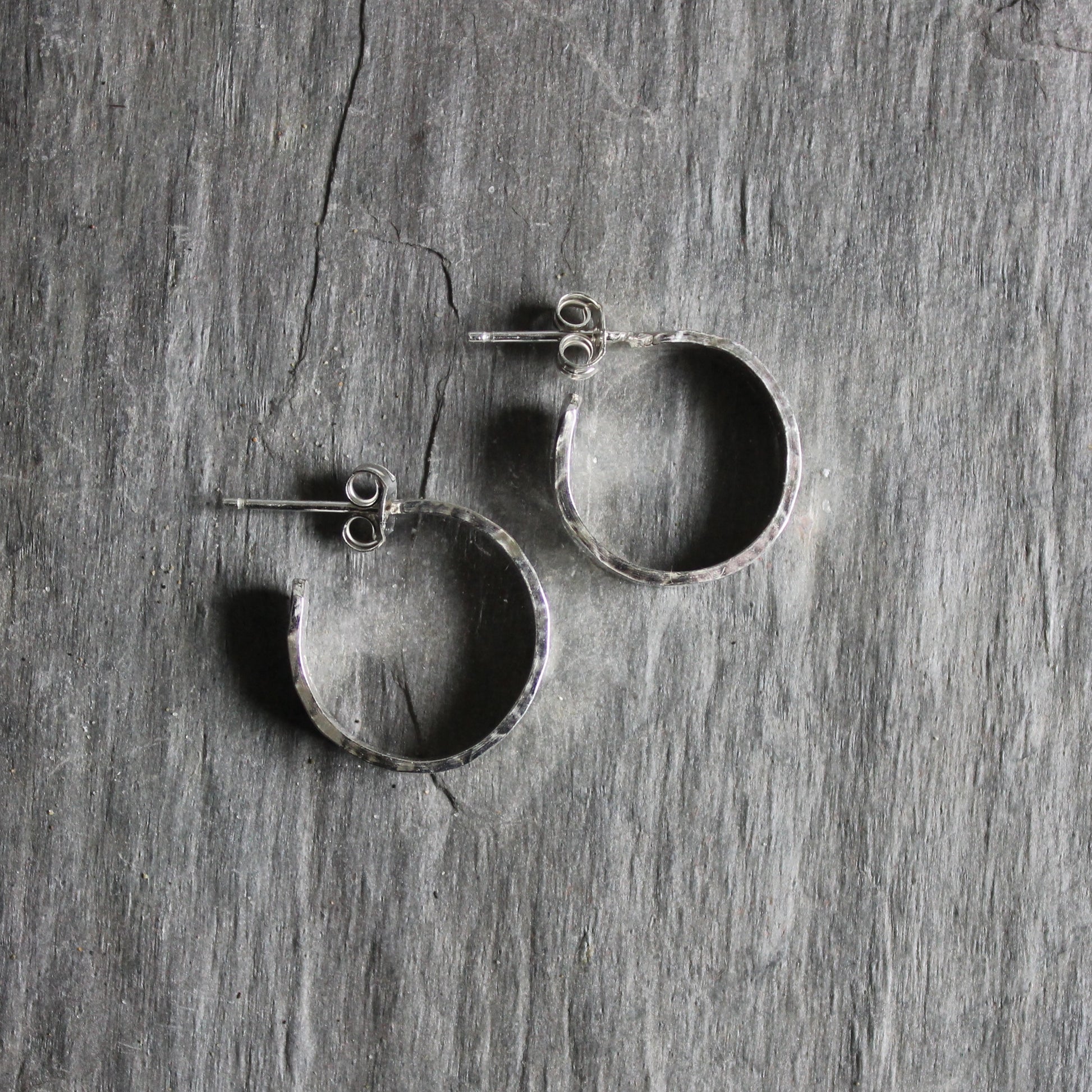these hoop earrings are made with 4mm x 1mm sterling silver and hammered into approximately 3/4 inch diameter hoop earrings with silver posts. 
