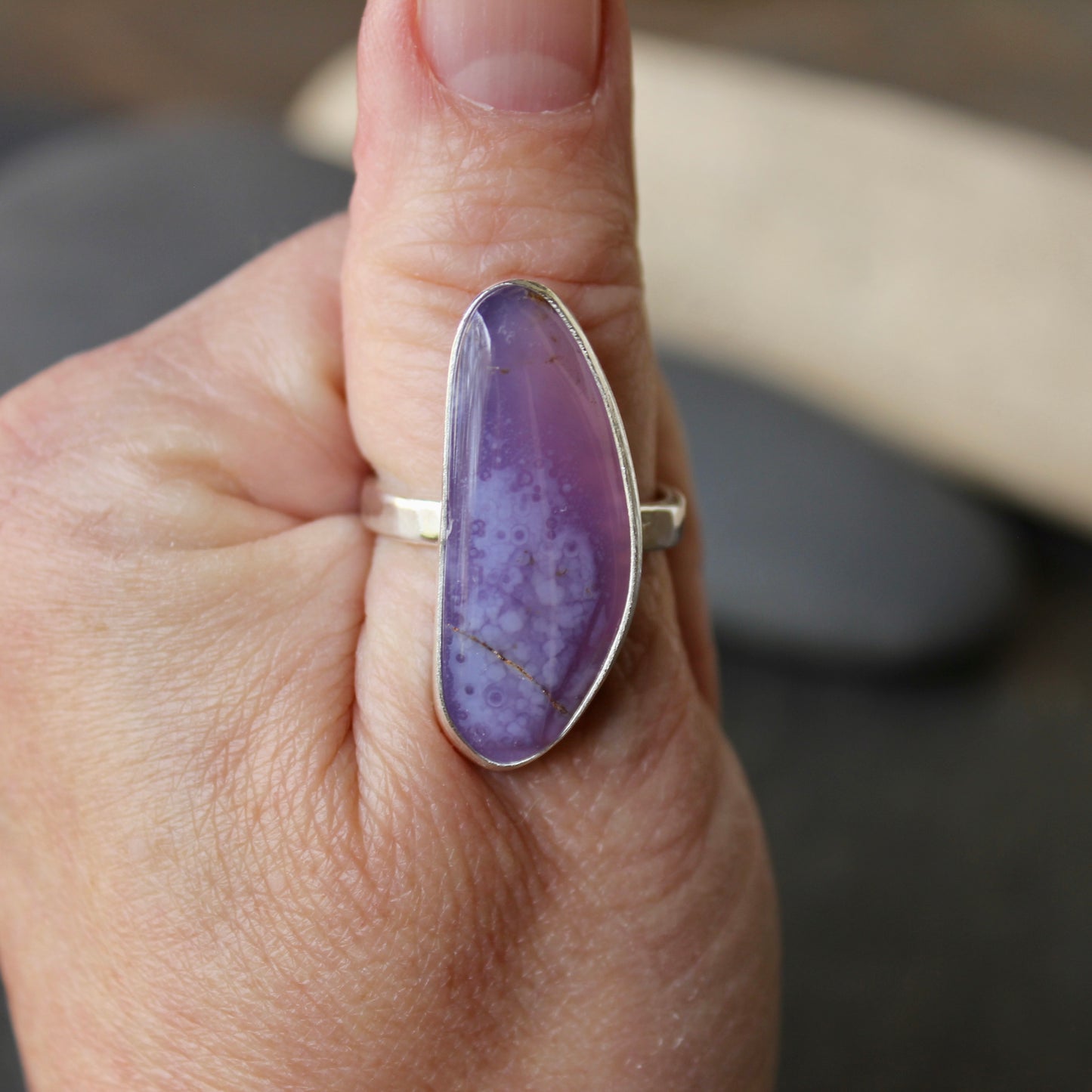 a large holley blue statement ring on a thumb size 11