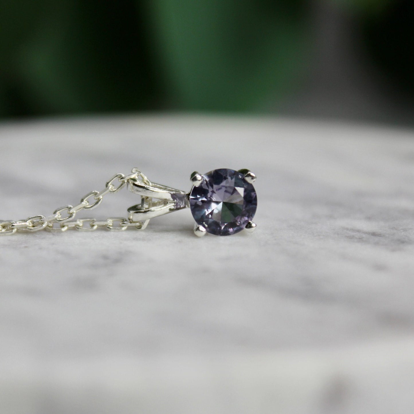 This necklace has a 6mm round faceted simulated alexandrite set in a 4-prong sterling silver pendant setting on a sterling silver chain.