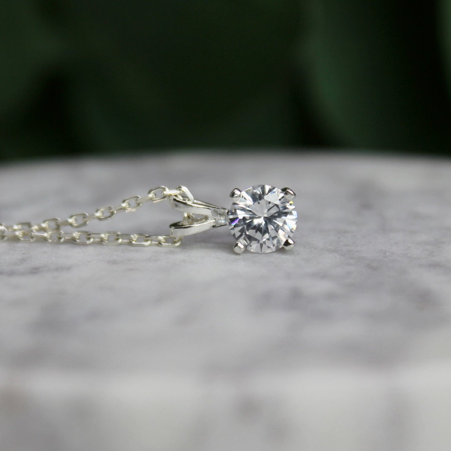 This necklace has a 6mm round faceted cubic zirconia set in a sterling silver 4-prong setting with a sterling silver chain.