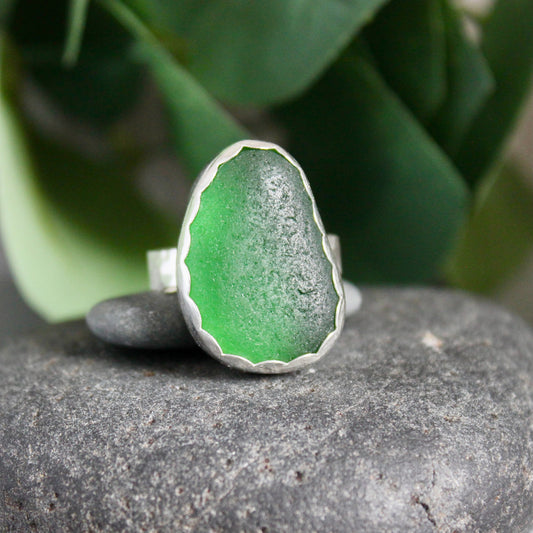 This is a large chunky piece of European dark emerald green sea glass that is set in a fine & sterling silver scalloped bezel setting and on a sturdy silver band.  Size 10 1/2
