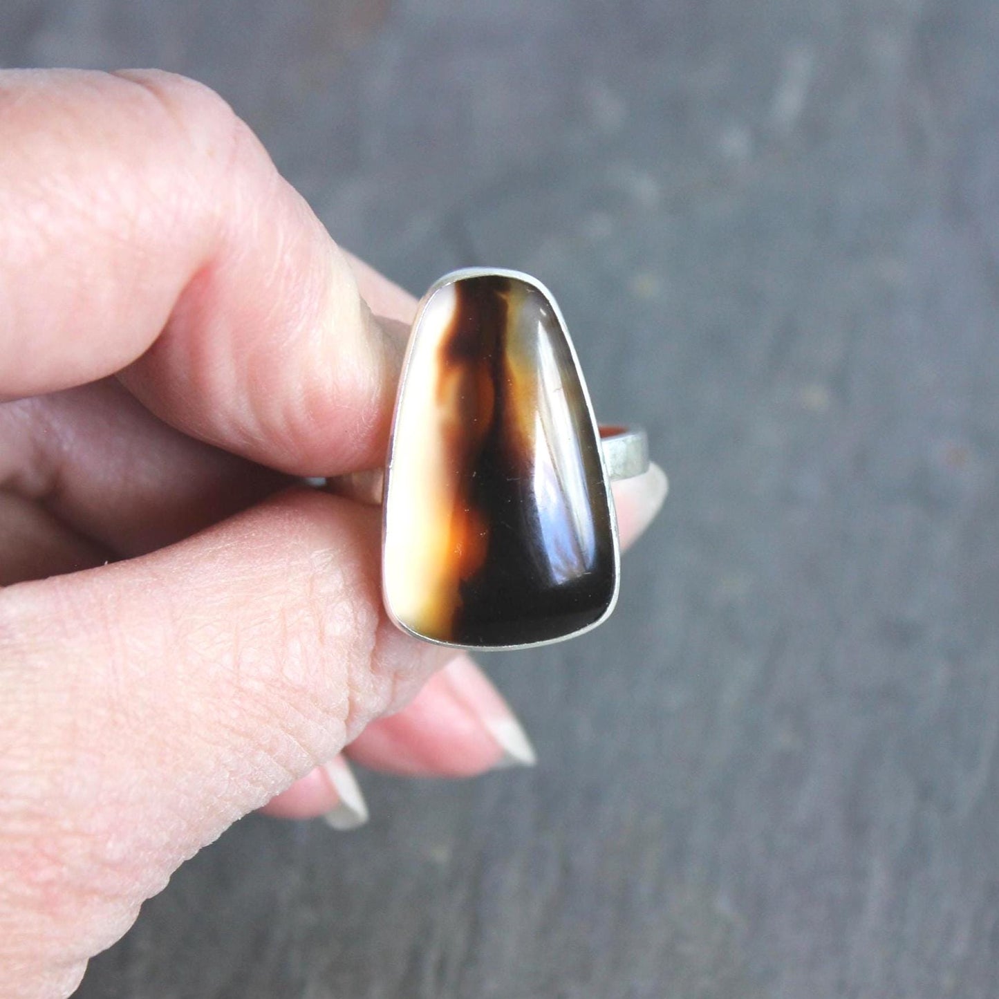 This ring has a large Montana agate cabochon set in a fine and sterling silver bezel setting on a sturdy hammered band. Handmade by Will Macy in Corvallis, OR.