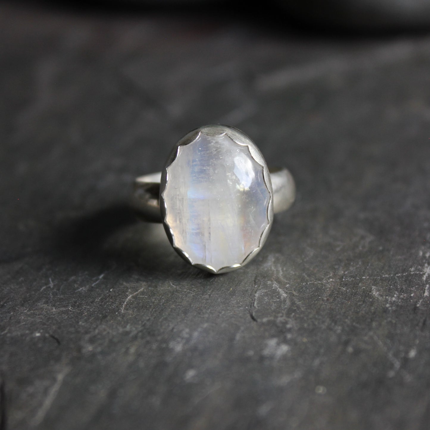 This is a huge ring with a flashy rainbow moonstone set in a fine & sterling silver scalloped bezel on sturdy silver band.  Size 11 3/4