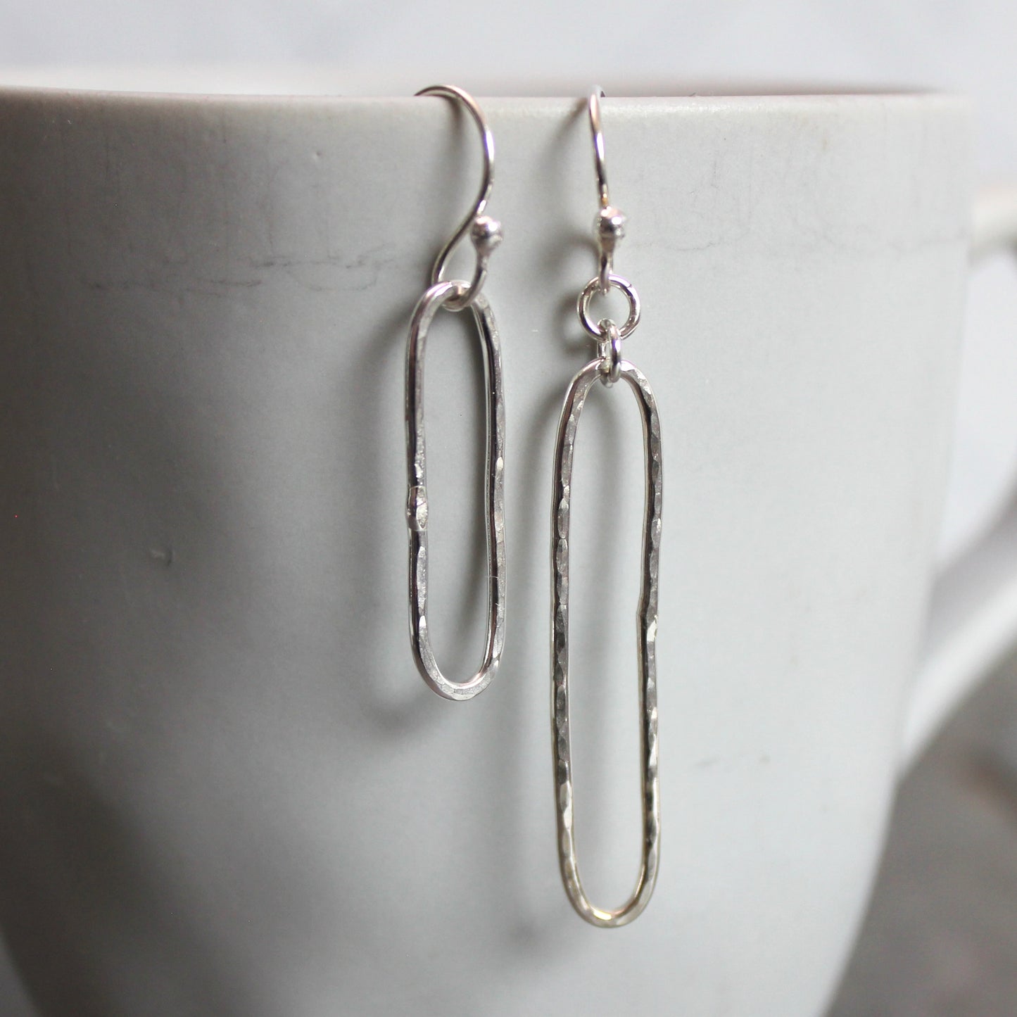 Silver earrings on a marble surface