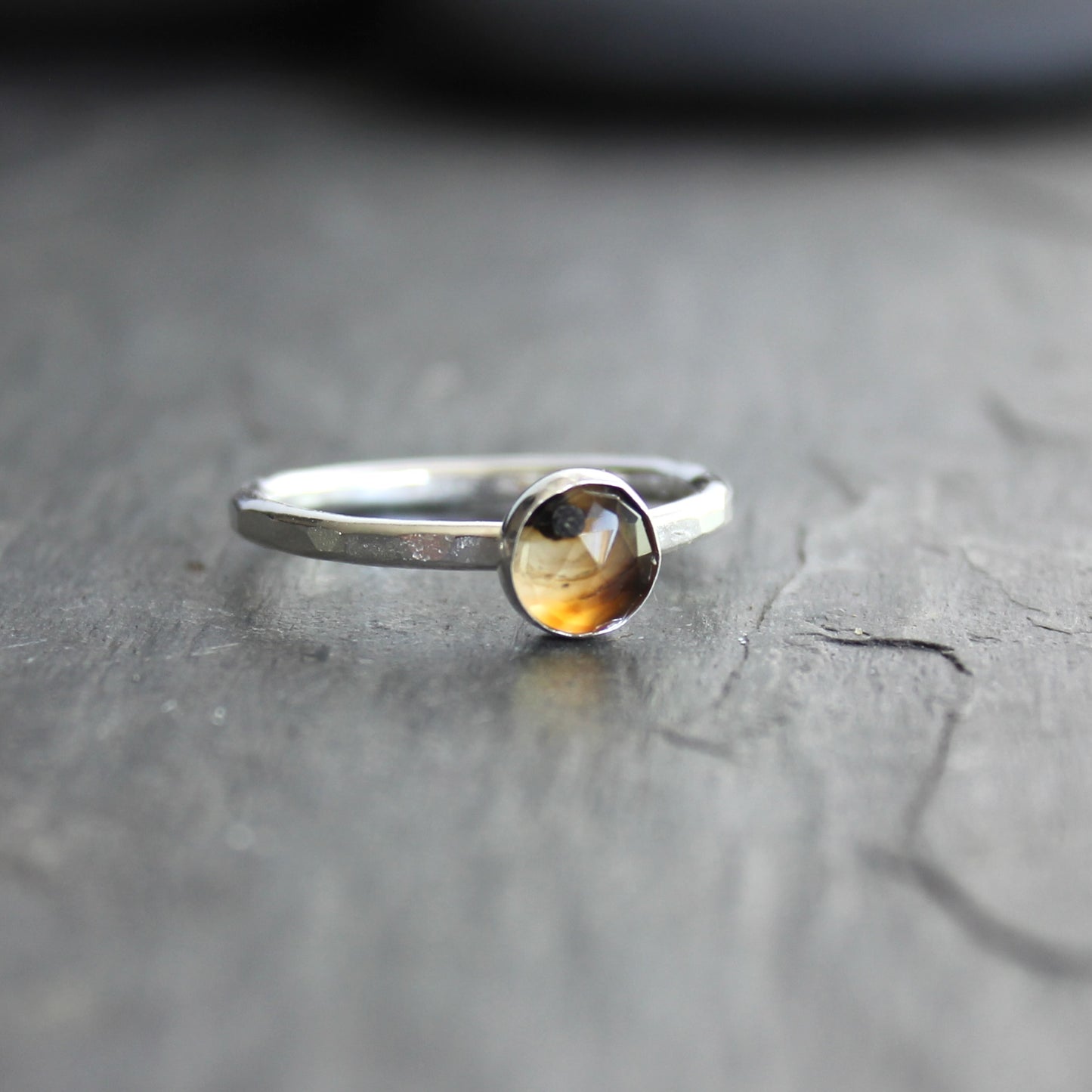 Silver ring with a rose cut montana agate on a gray surface