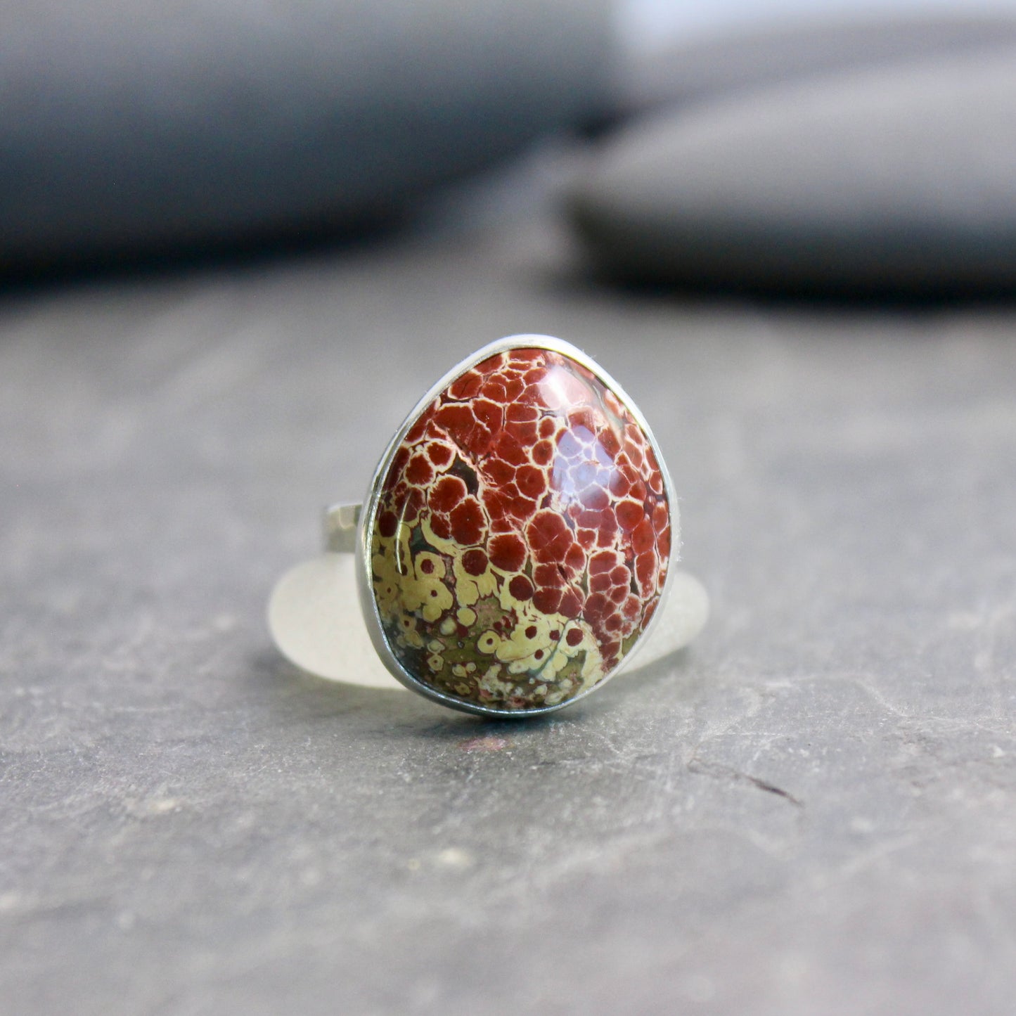 Ring with a marbled stone on a gray surface