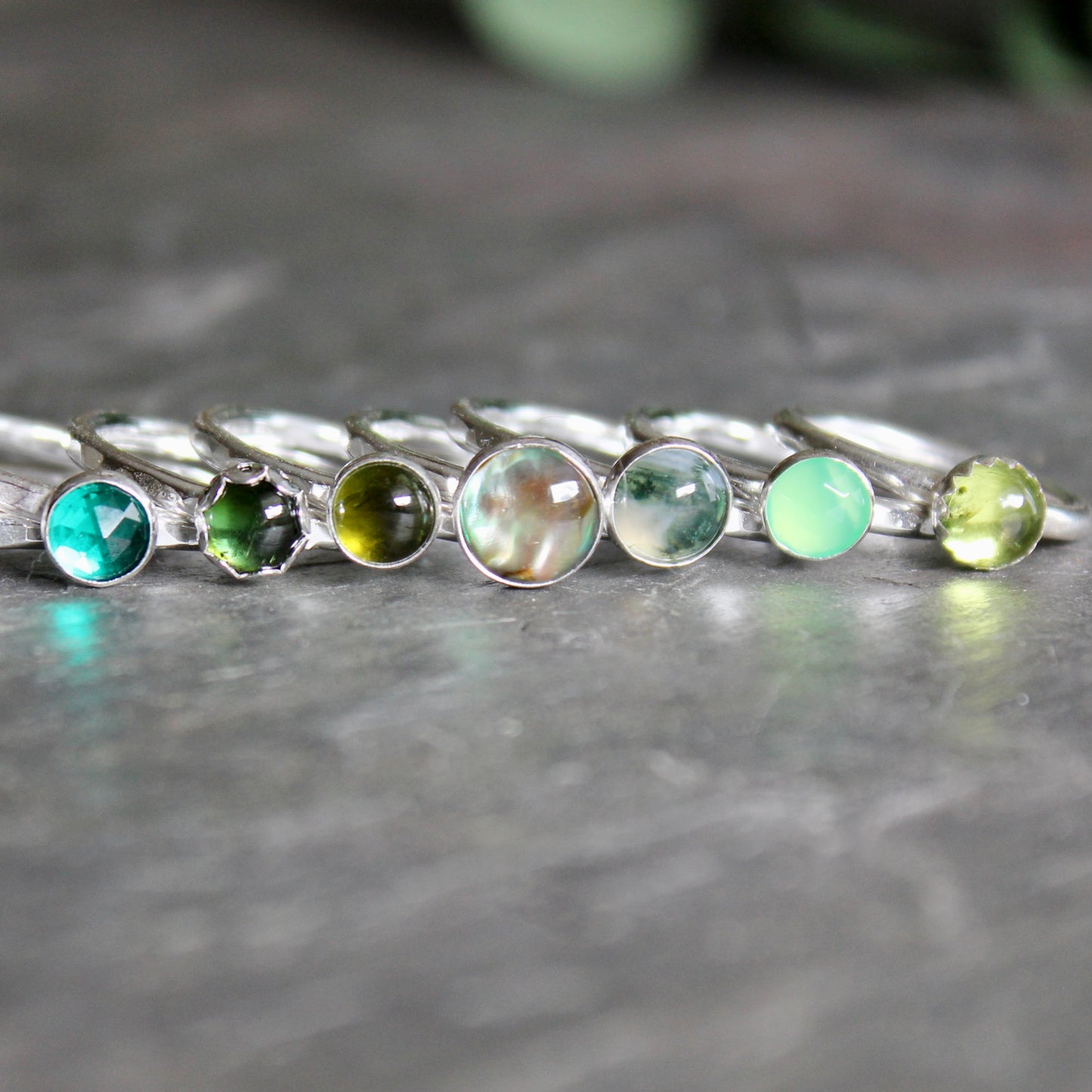 a row of green gemstone stacking rings