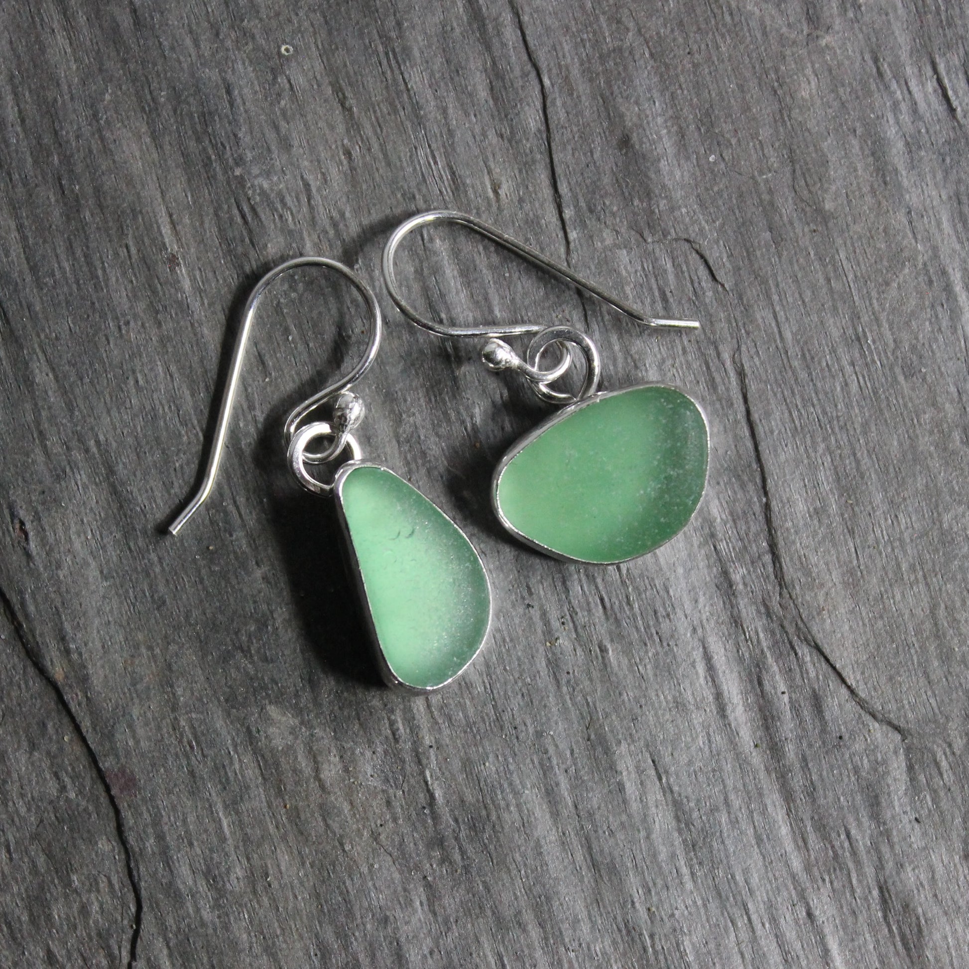 These mismatched dangly sage green earrings are set in a fine & sterling silver bezel setting on handmade ear wires. 