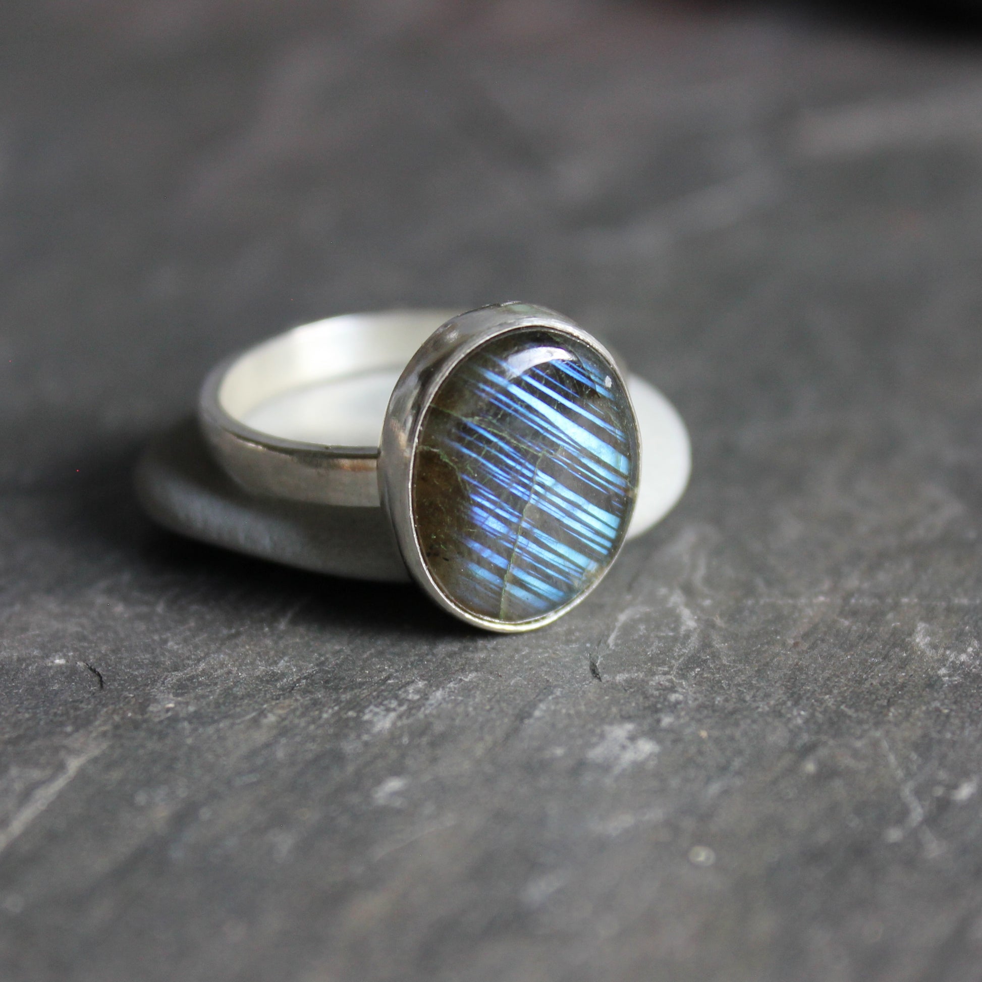 This ring has a small oval labradorite set in a fine & sterling silver bezel setting on a sturdy hammered band.  Size 12