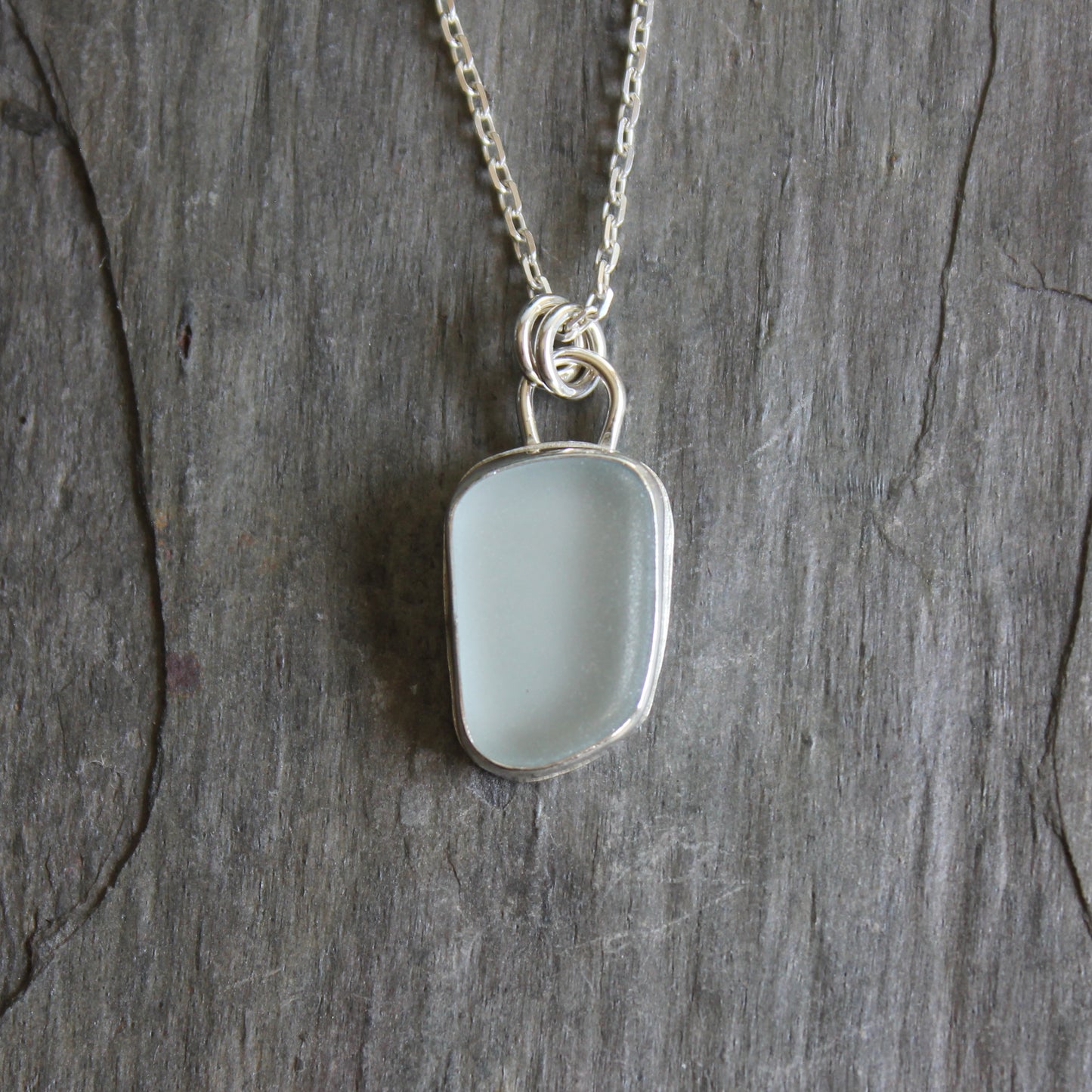 This is a pale powder blue piece of sea glass set in a fine & sterling silver bezel setting on an 18 inch chain. 