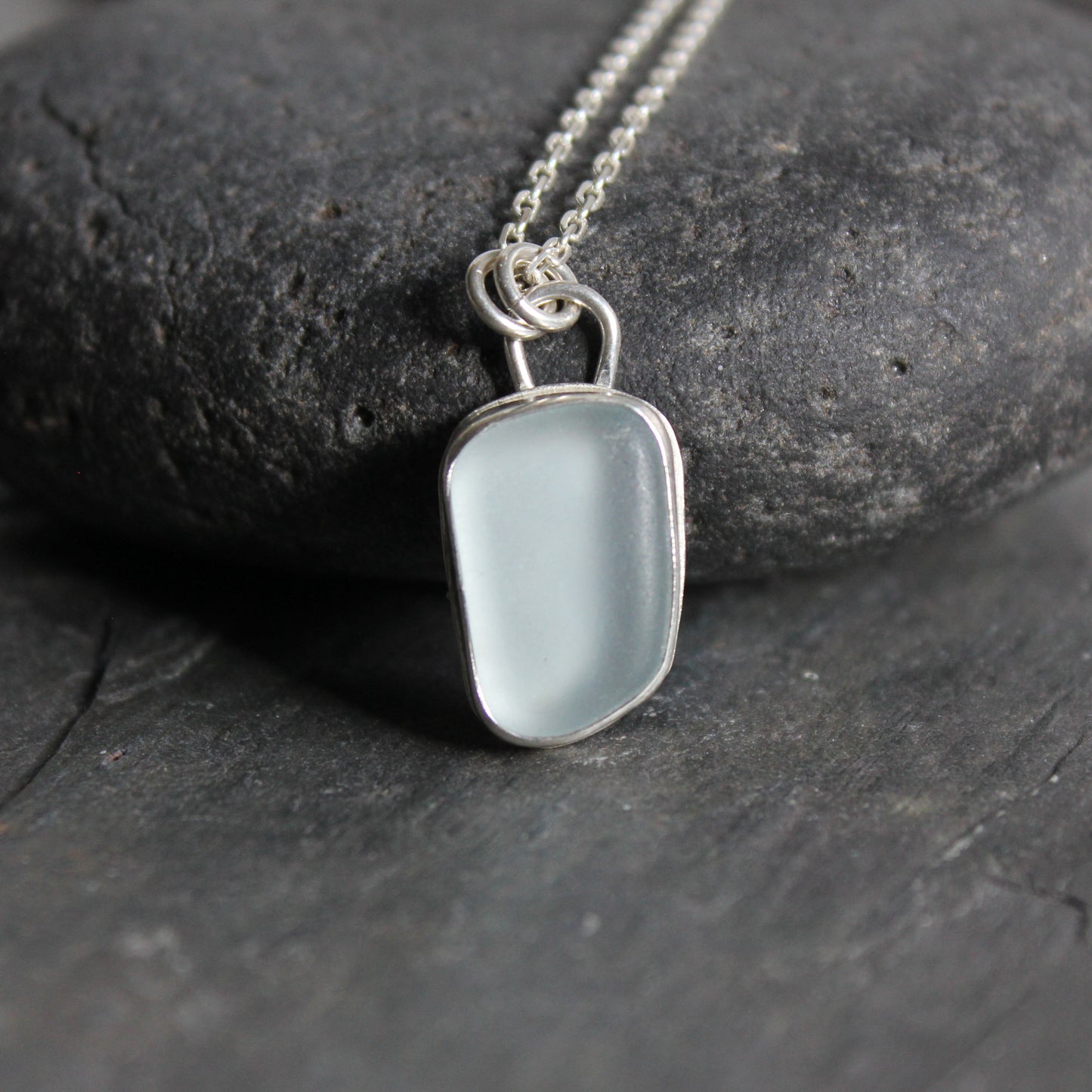 This is a pale powder blue piece of sea glass set in a fine & sterling silver bezel setting on an 18 inch chain. 
