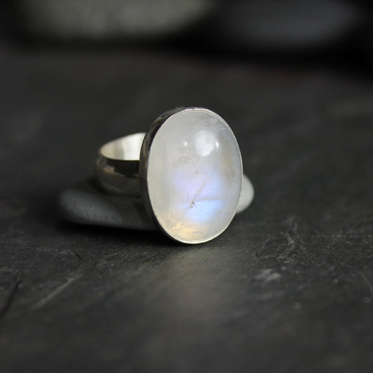 This is a large chunky rainbow moonstone cabochon set in a fine and sterling silver bezel setting on a sturdy hammered silver band.  Size 7 1/2