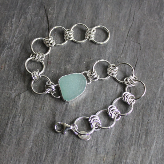 This is a large piece of teal sea glass that is in a simple bezel setting and attached to a hefty handmade chain and a lobster clasp. . 7.5 inches and can be resized. 