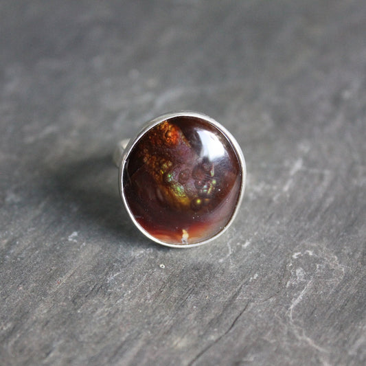 This is a large roundish Mexican fire opal that is set in a fine and sterling silver bezel setting on a sturdy silver band. Size 8 1/4