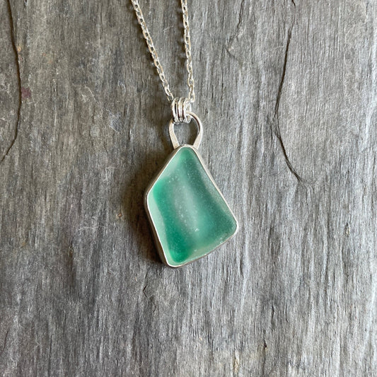 Ultra rare green and white sea glass set in a fine & sterling silver bezel setting on an 18" chain. 