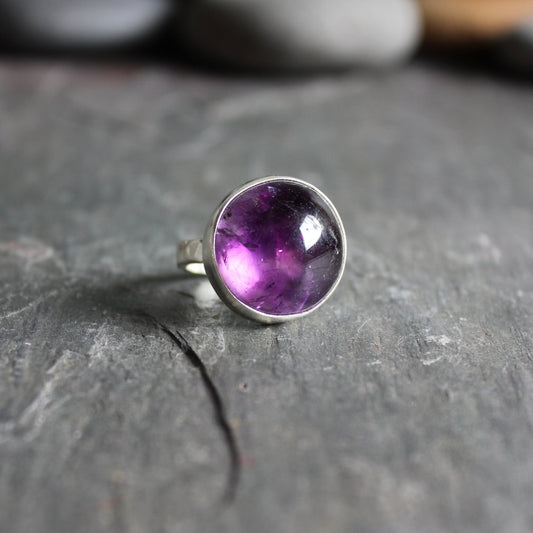 This is a chunky round Brazilian amethyst set in a fine and sterling silver bezel setting on a sturdy hammered band.  Size 5 1/2