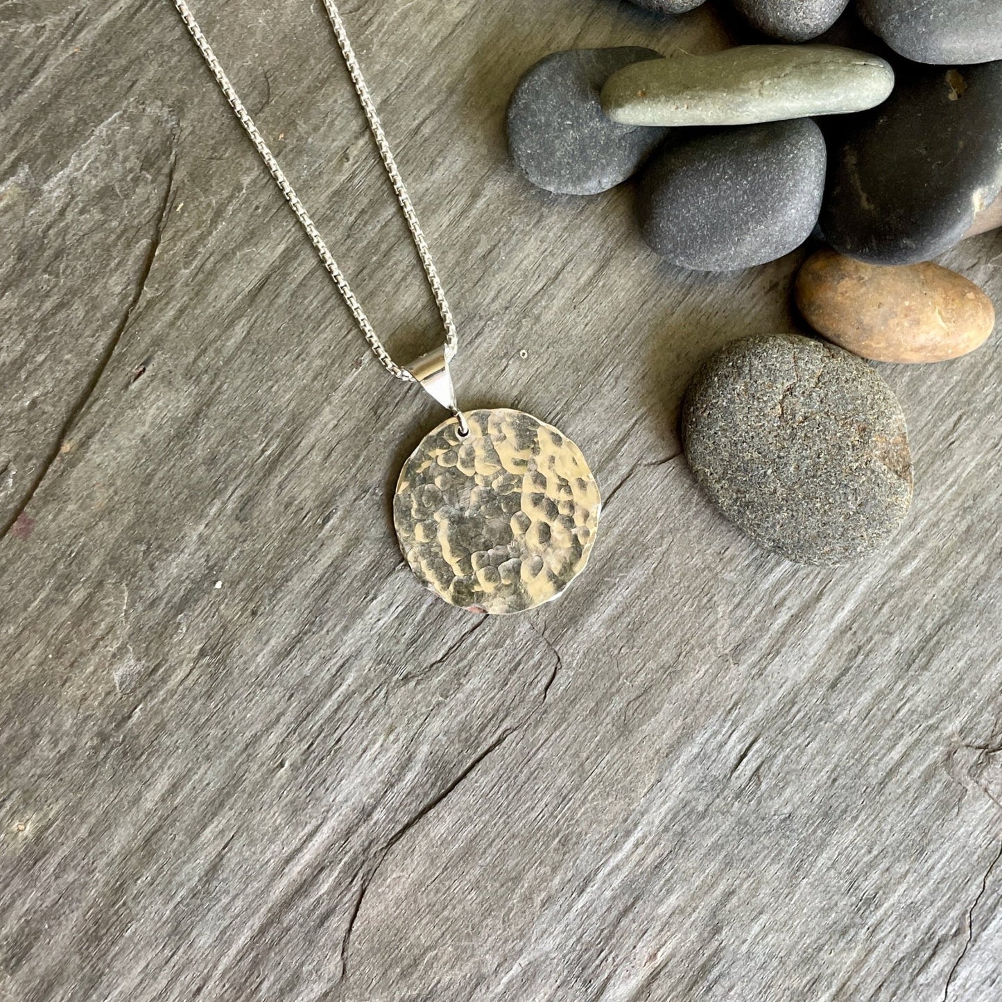 This necklace has an approximately 1 inch hammered sterling silver disc that comes on a sterling silver chain.  Size comparable to a quarter. 