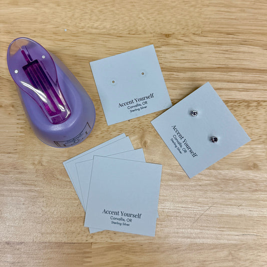 A pair of earrings with small business cards that get hole punched and turned into earring cards and packaging. 