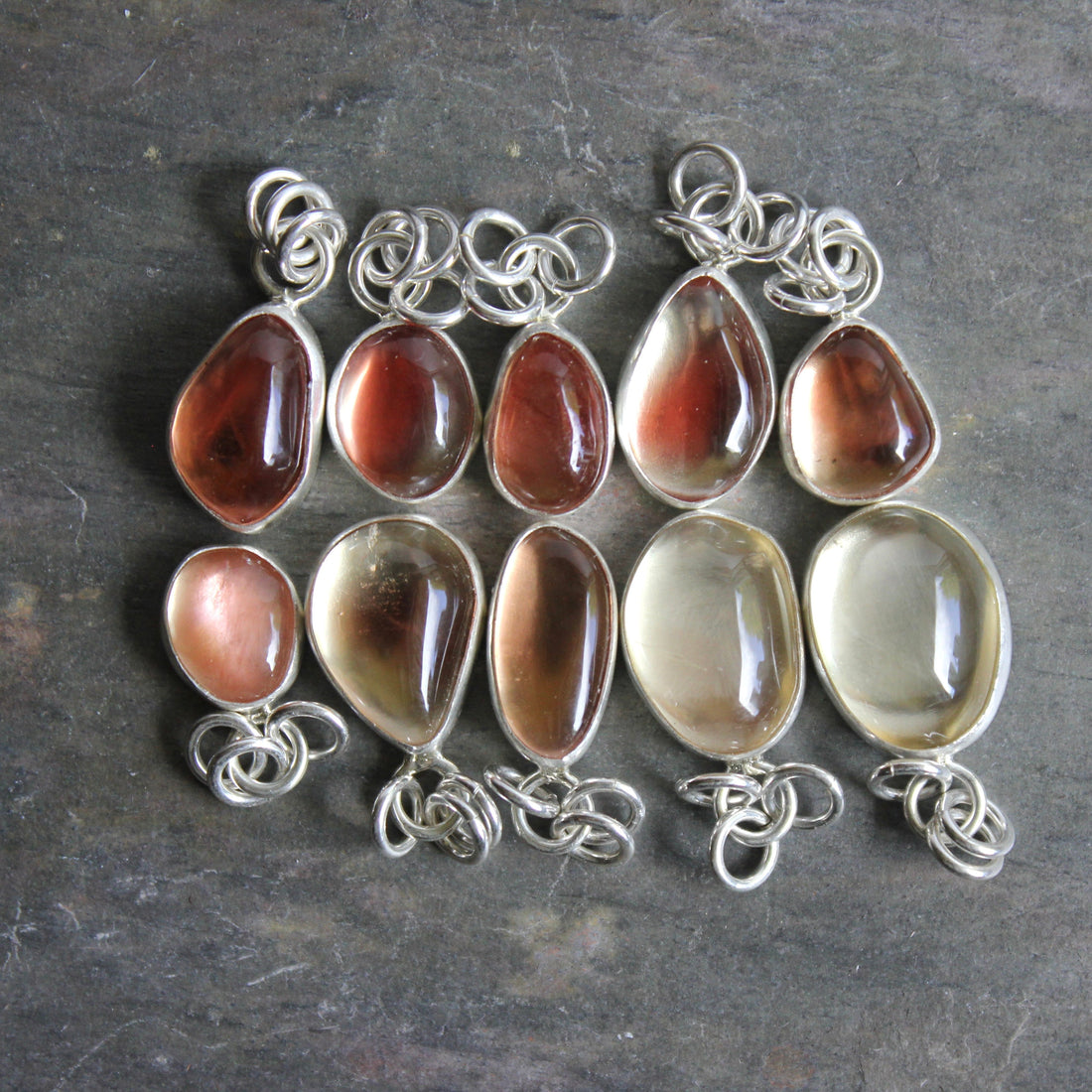 Oregon sunstone pendants displayed for sale in an Etsy shop and at a market booth.