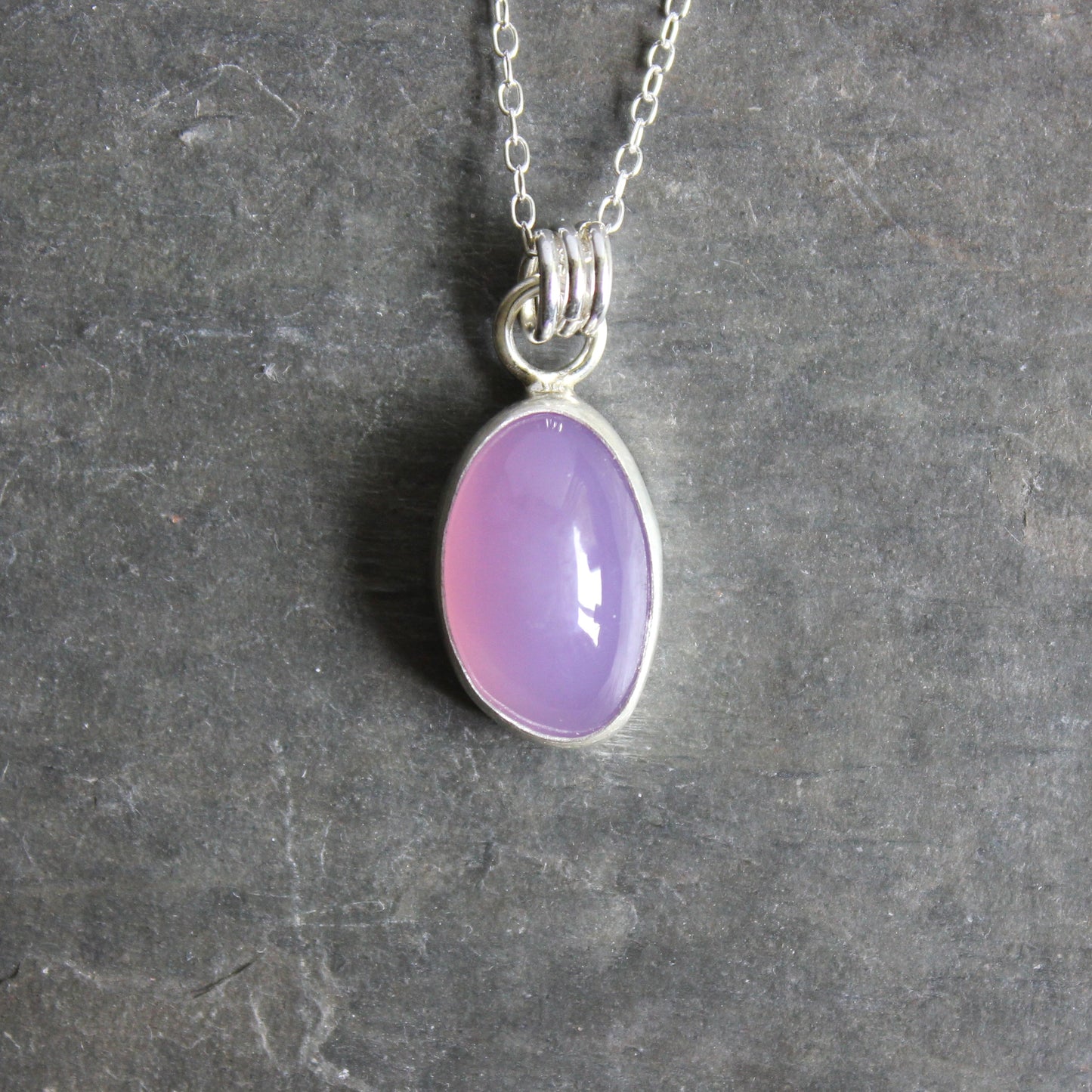 Holley Blue Agate pendant on a silver chain against a gray background
