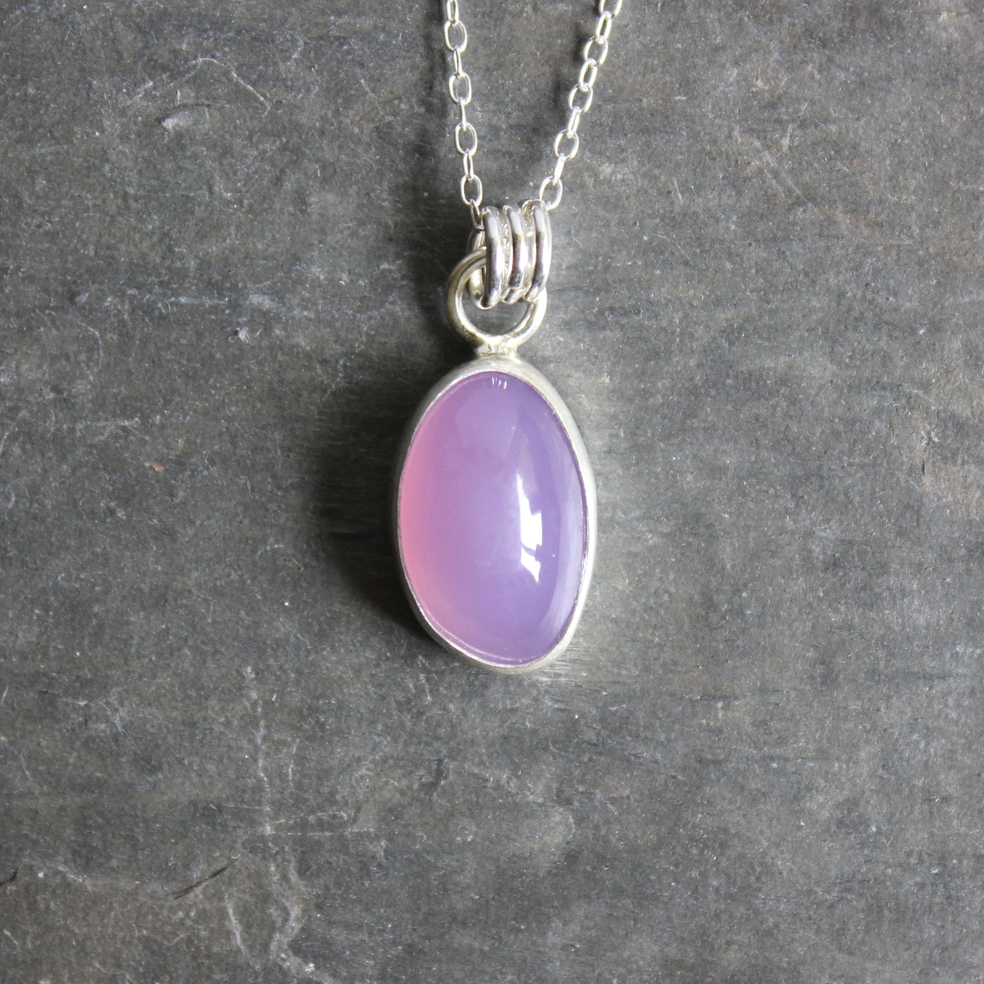 Holley Blue Agate pendant on a silver chain against a gray background