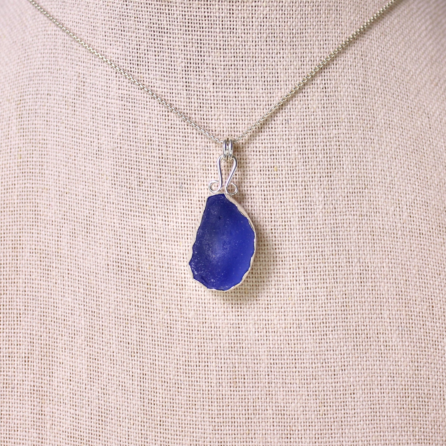 Sterling silver cobalt sea glass set in a fine and sterling silver bezel setting on a sterling silver chain.