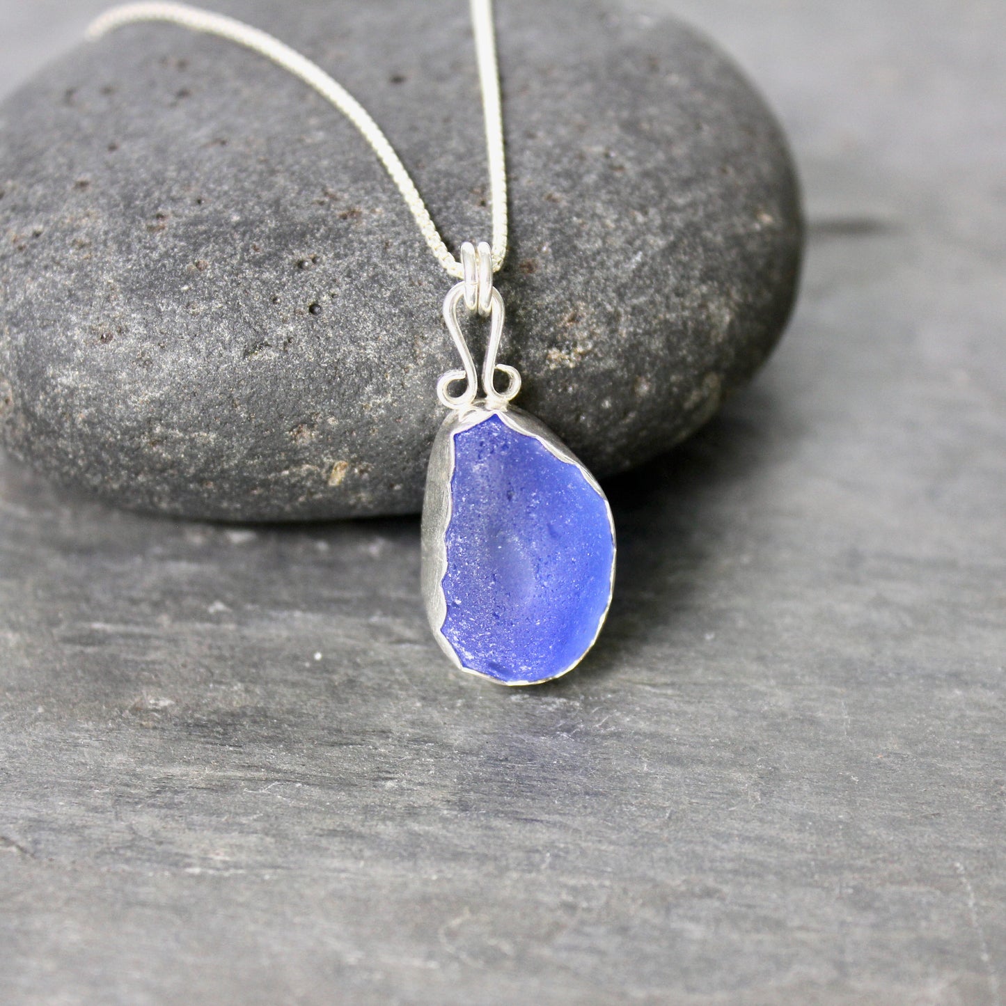 Sterling silver cobalt sea glass set in a fine and sterling silver bezel setting on a sterling silver chain.