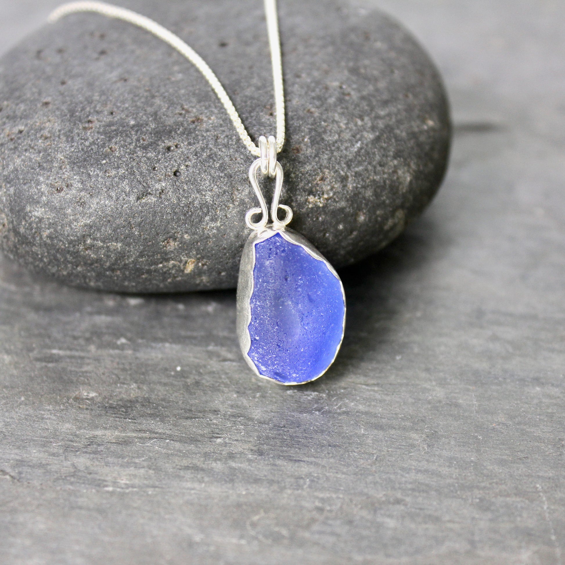 Sterling silver cobalt sea glass set in a fine and sterling silver bezel setting on a sterling silver chain.